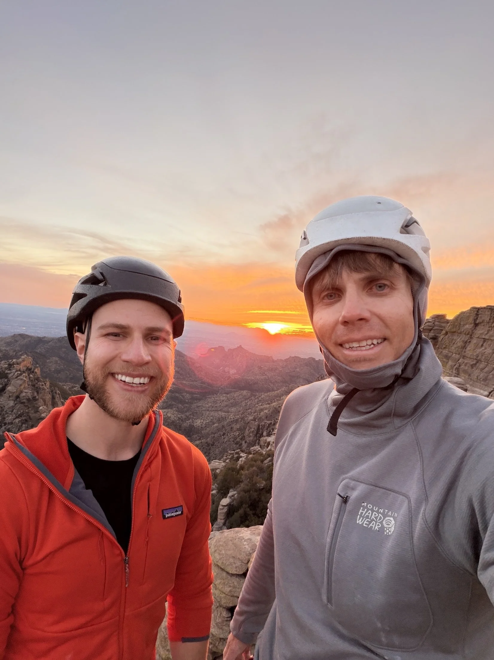 Two climbers at a Mount Lemmon overlook at sunset.