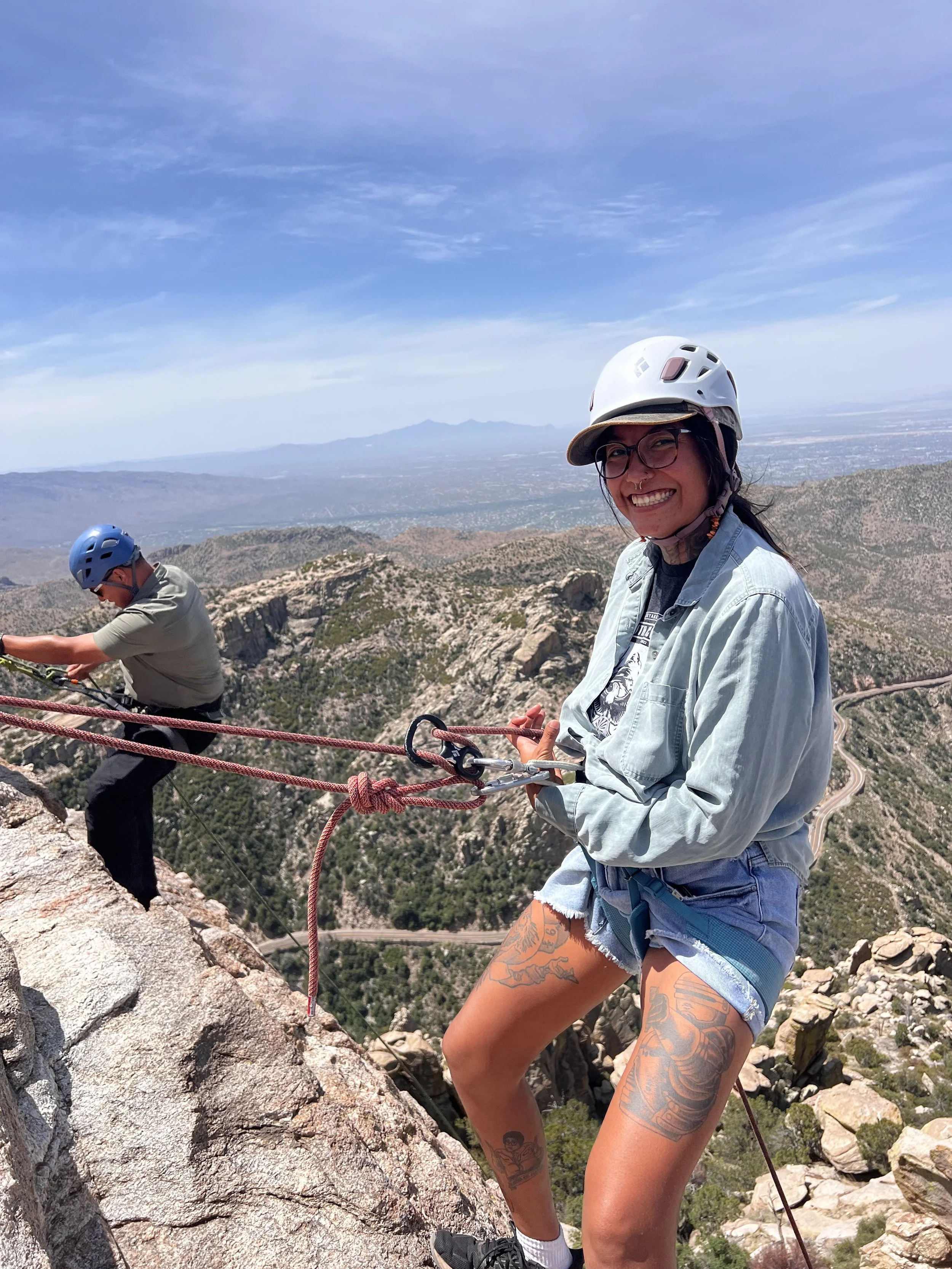 Guest using a rappel system with ropes, harness and helmet on Mount Lemmon