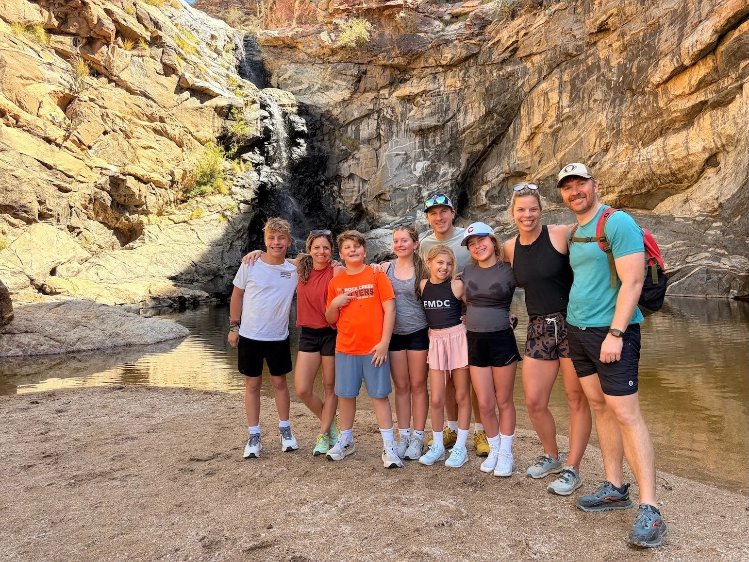 Family canyoneering with waterfall in background in Tucson, AZ