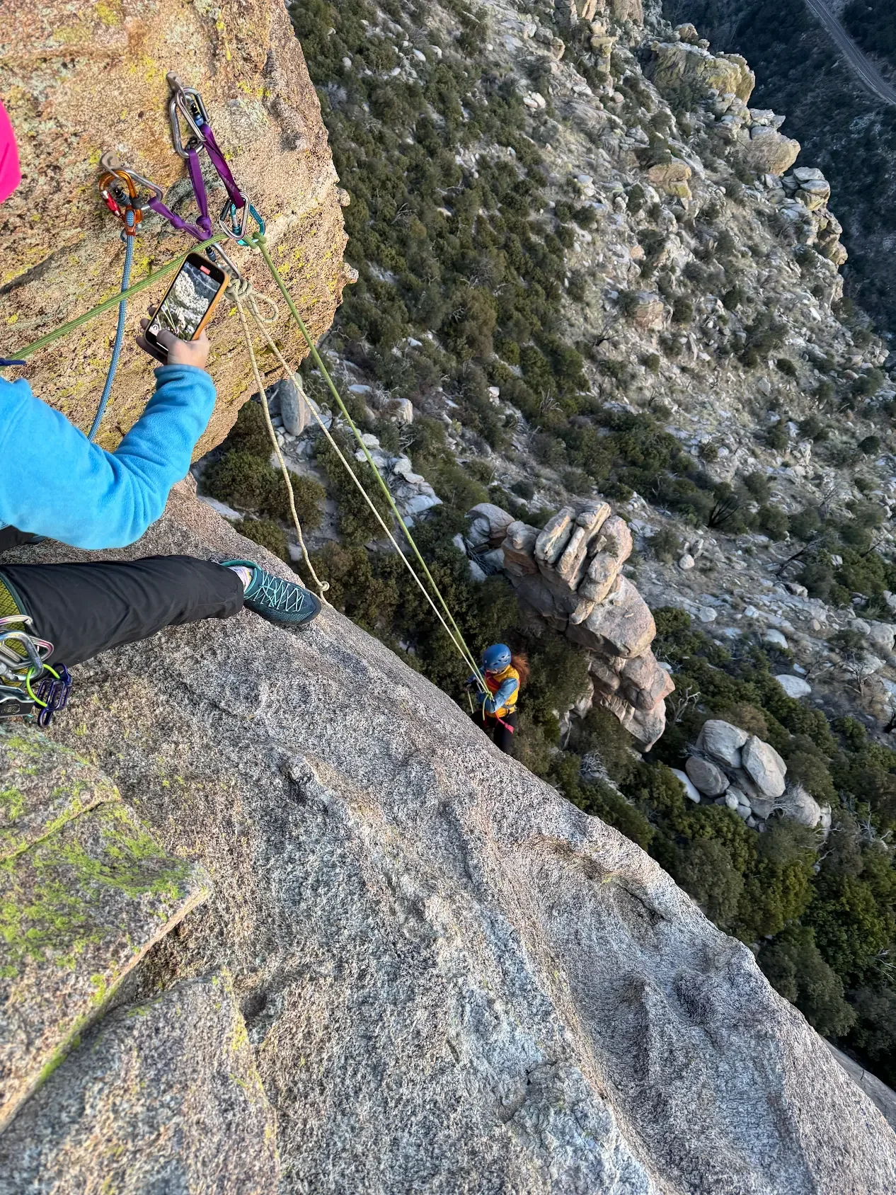 Rappeller descending a granite cliff on Mount Lemmon with a guide above