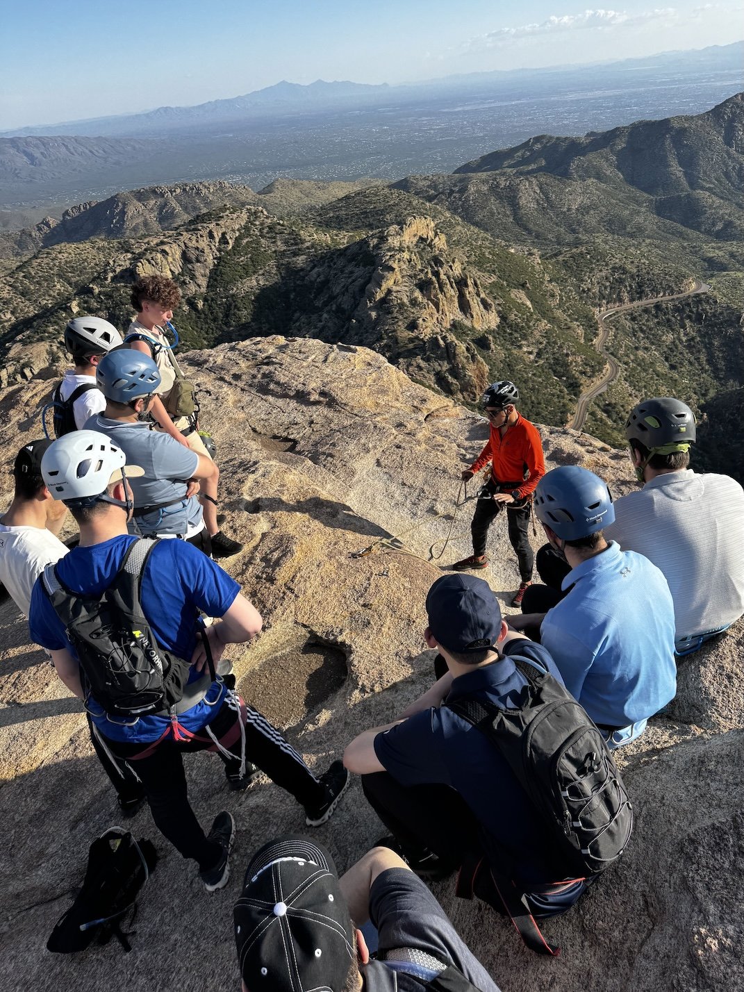 Guide giving rappelling instruction to a group on Mount Lemmon