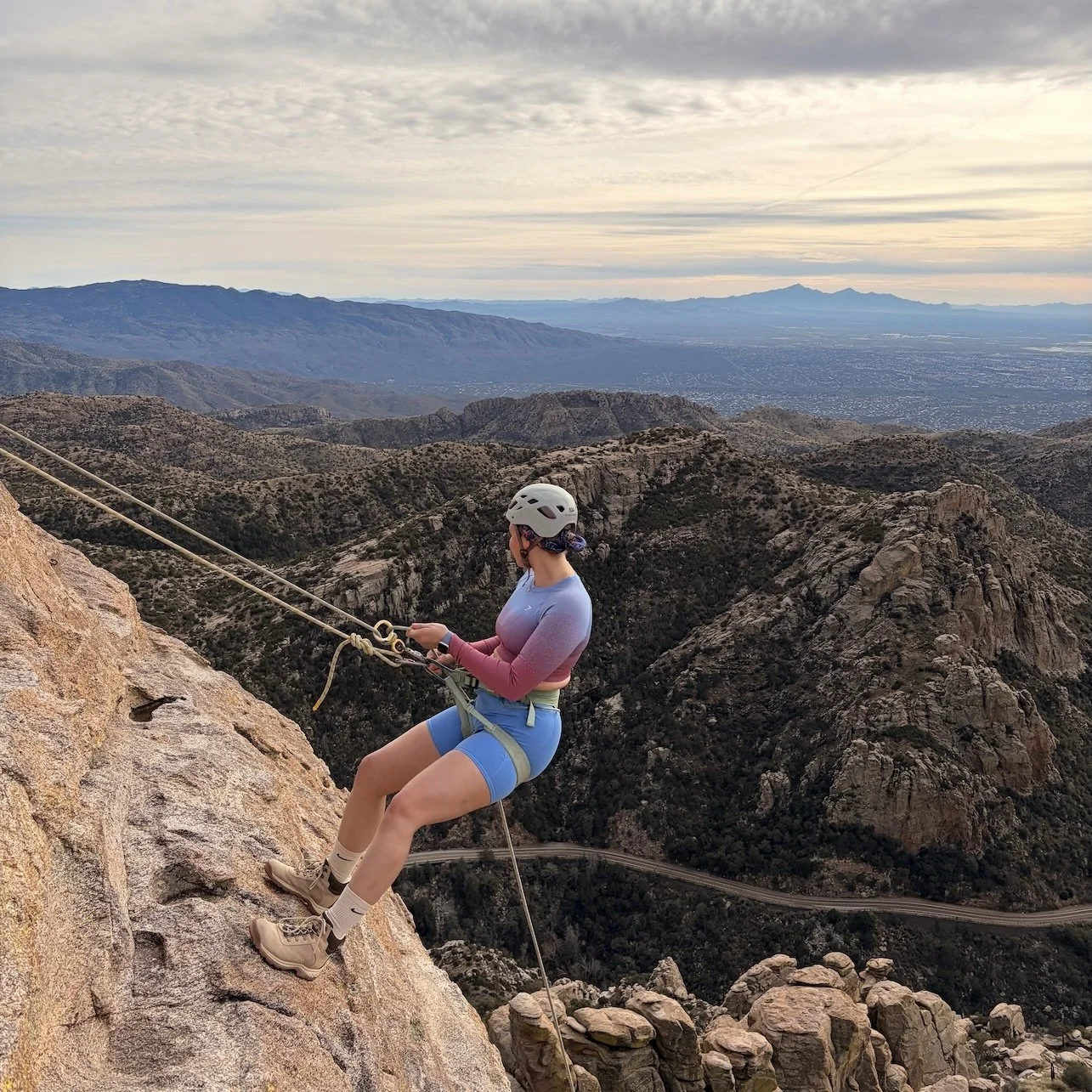 Woman rappelling on Mount Lemmon with views of Tucson and the Santa Catalina Mountains