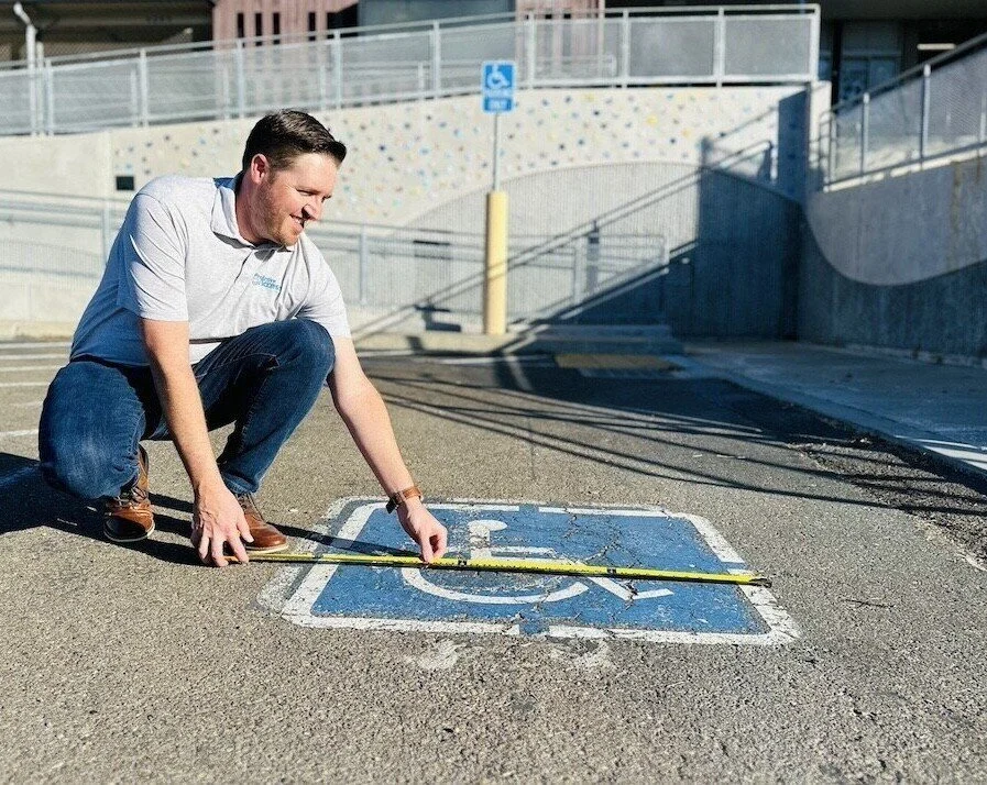 Accessibility professional surveying an accessible parking stall.