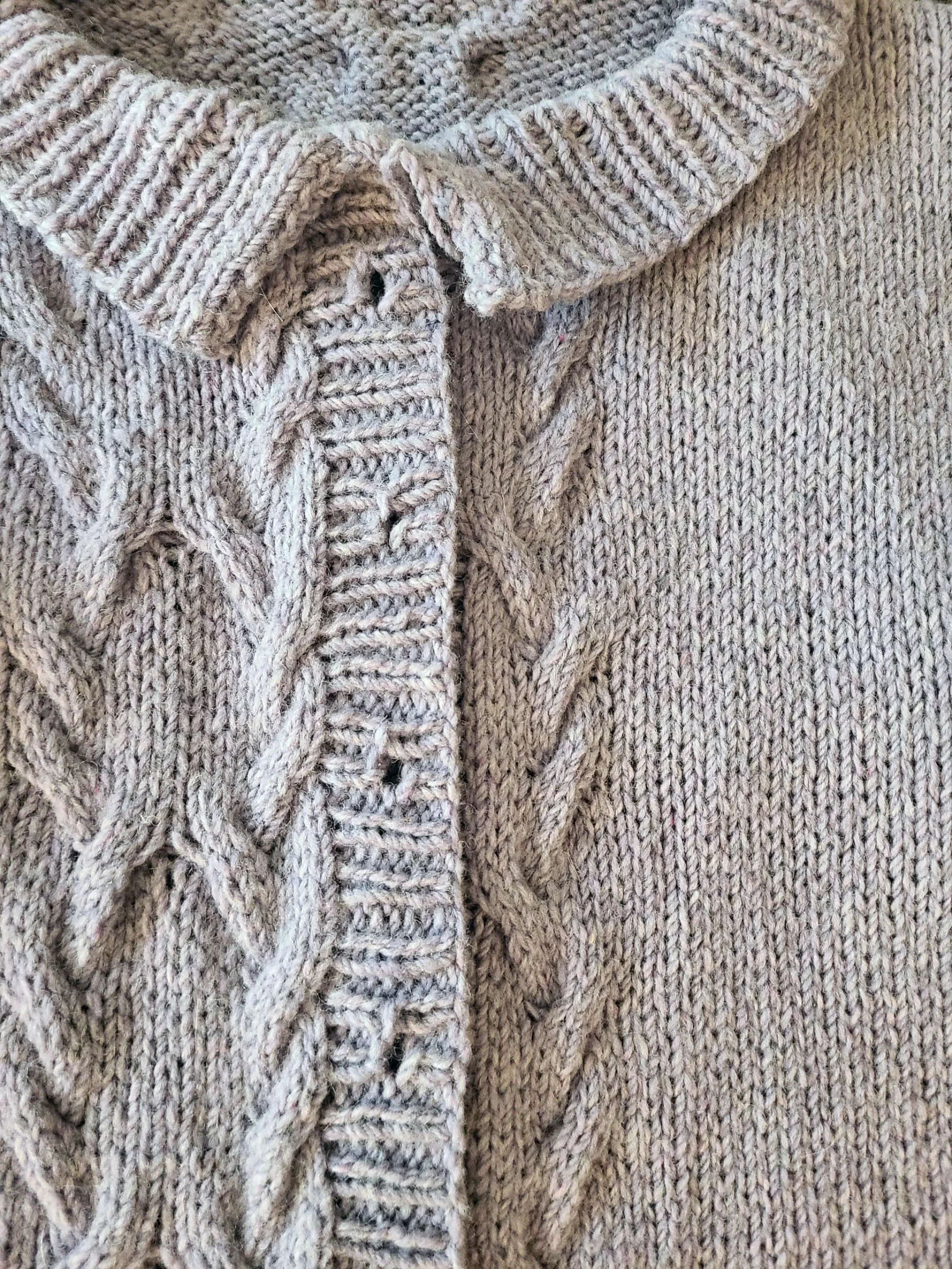 photo of a knit cardigan with no buttons laid on a flat surface with the fronts overlapping.