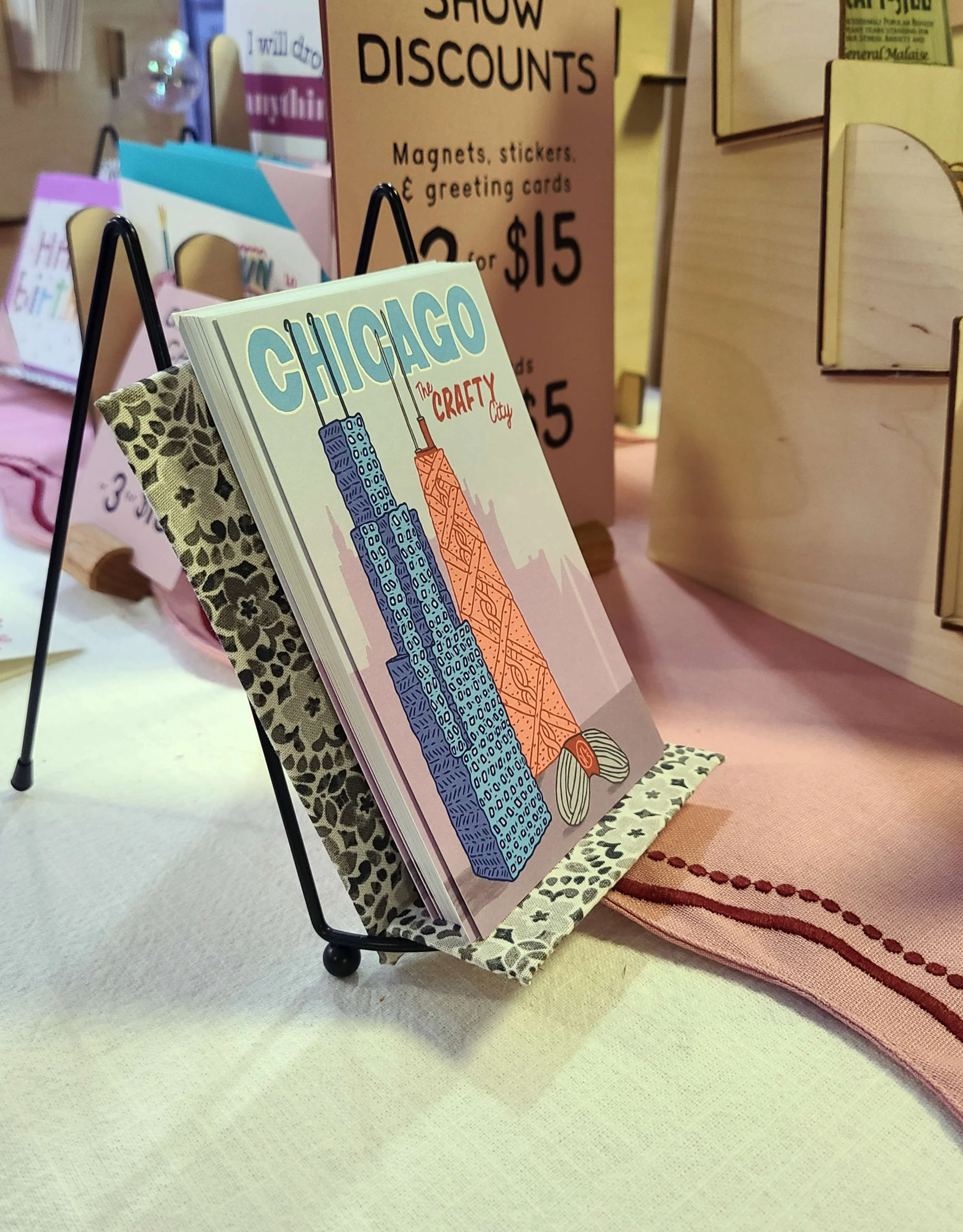 Photo of a stack of postcards resting on an assembled tabletop easel with an easel seat diy.
