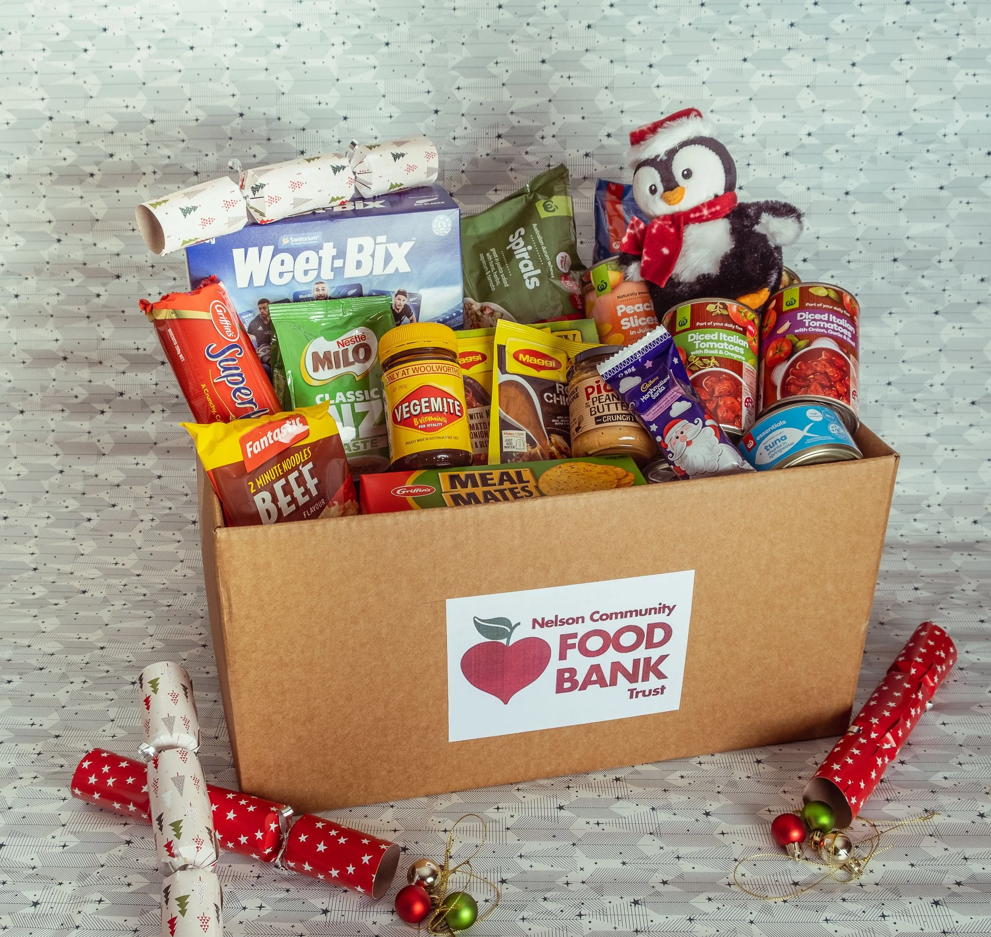 Box of food supplies from Nelson Community Food Bank with holiday decorations.