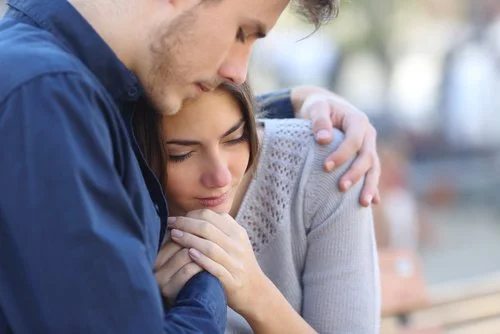 Man comforting woman outdoors