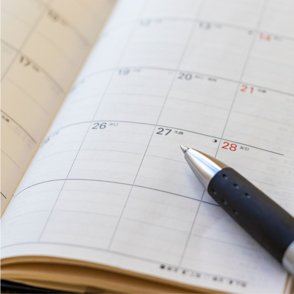 An image of a diary planner with a pen