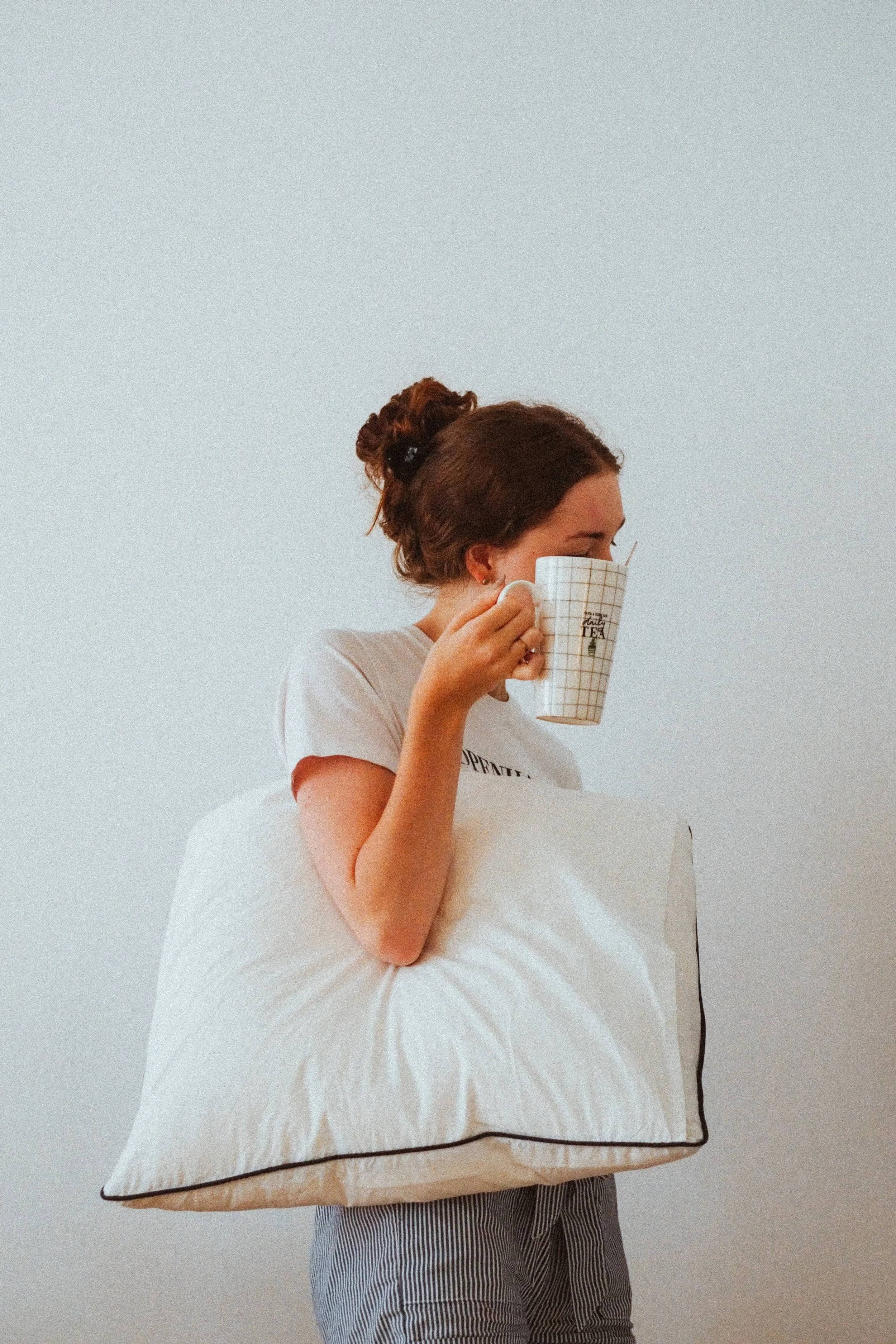 femme pyjama oreiller et tasse en main se reveille pour routine matinale freelance