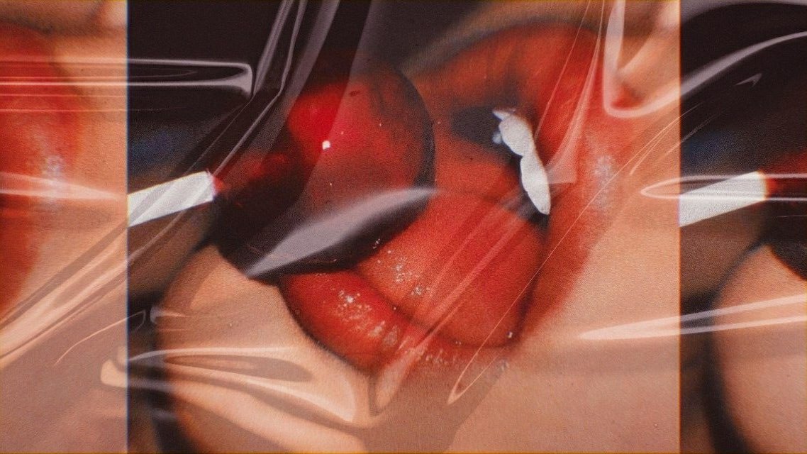 Editorial close-up of glossy red lips and a red lollipop, representing pleasure, desire and the complexity of women’s sexual health and wellbeing.