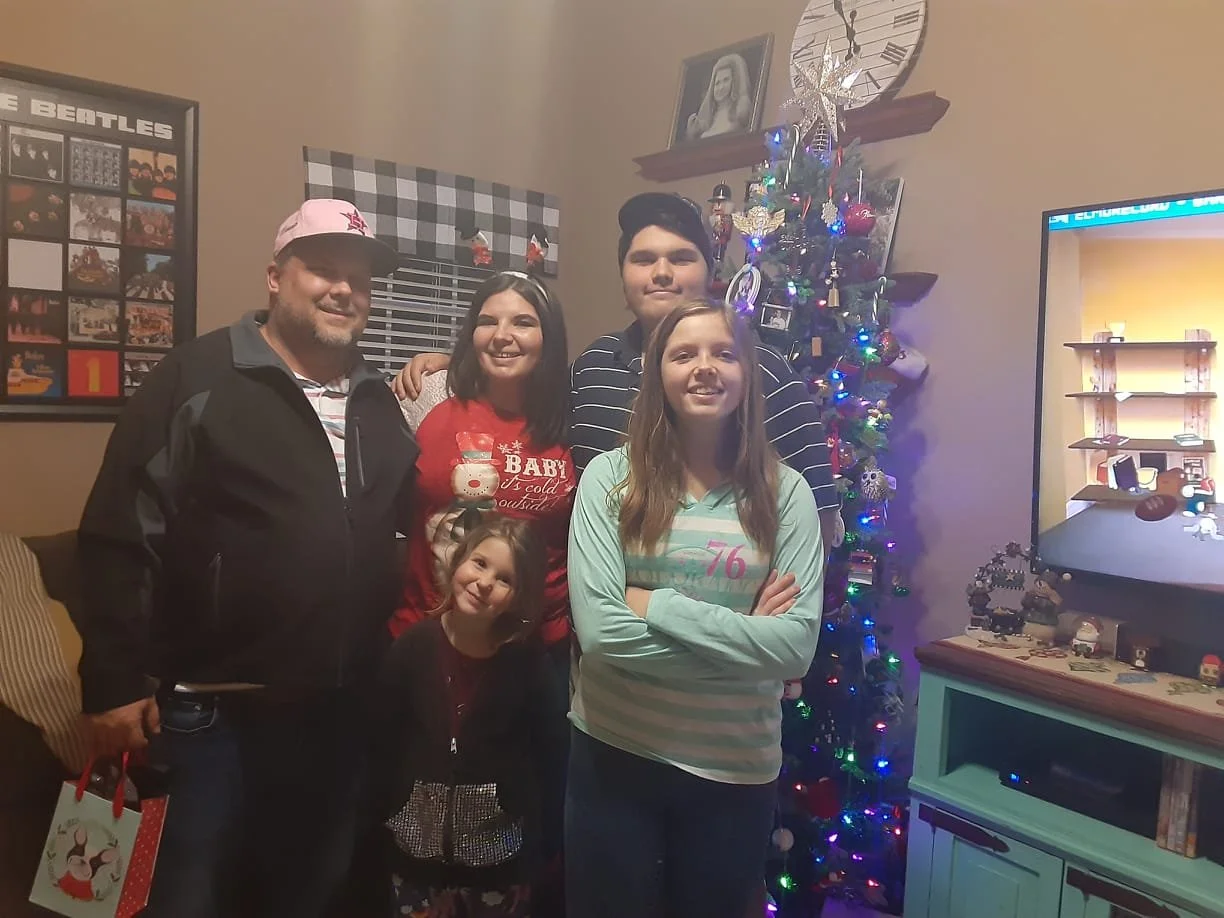 Midwife Amy with her husband and three children in front of their Christmas tree