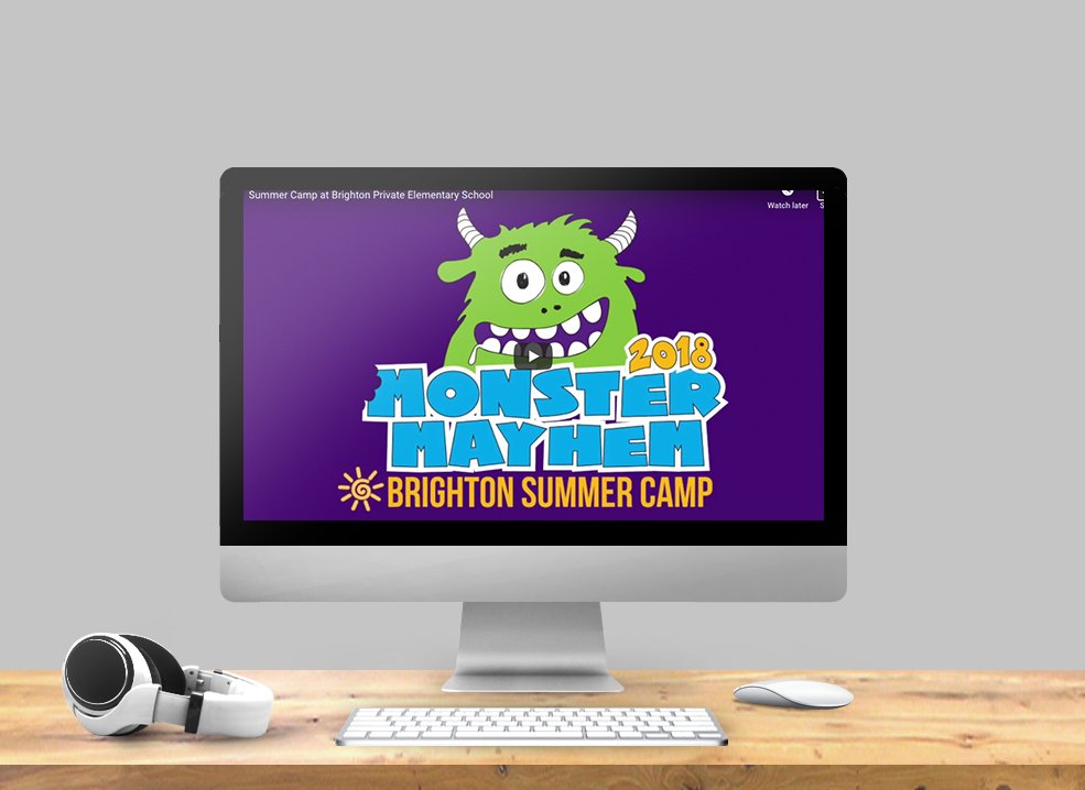 Computer monitor displaying a colorful graphic for the 2018 Monster Mayhem Brighton Summer Camp featuring a cartoon green monster with purple eyes, horns, and big teeth.