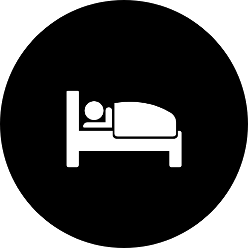 Icon of a person sleeping in a bed, with a pillow, inside a black circle.