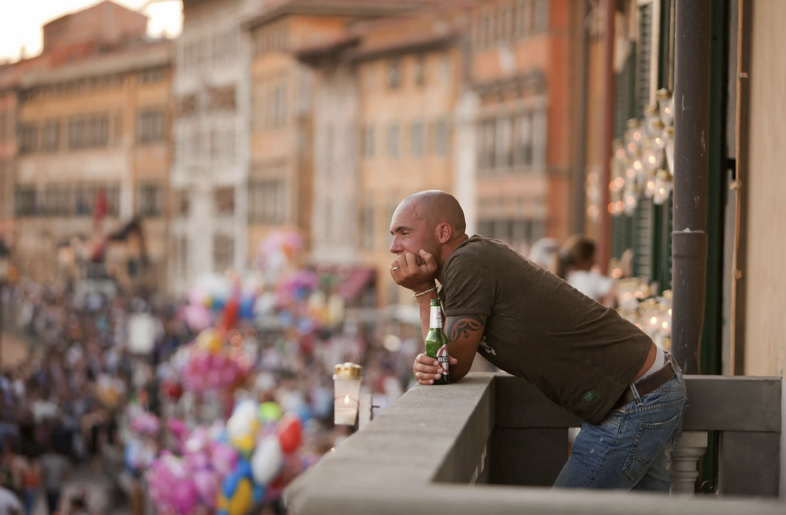 Interior de un edificio sin terminar o abandonado con paredes de hormigón visto, una escalera, una gran lona roja brillante cubriendo un objeto y un paisaje urbano con edificios altos al fondo a través de una ventana o puerta abierta.