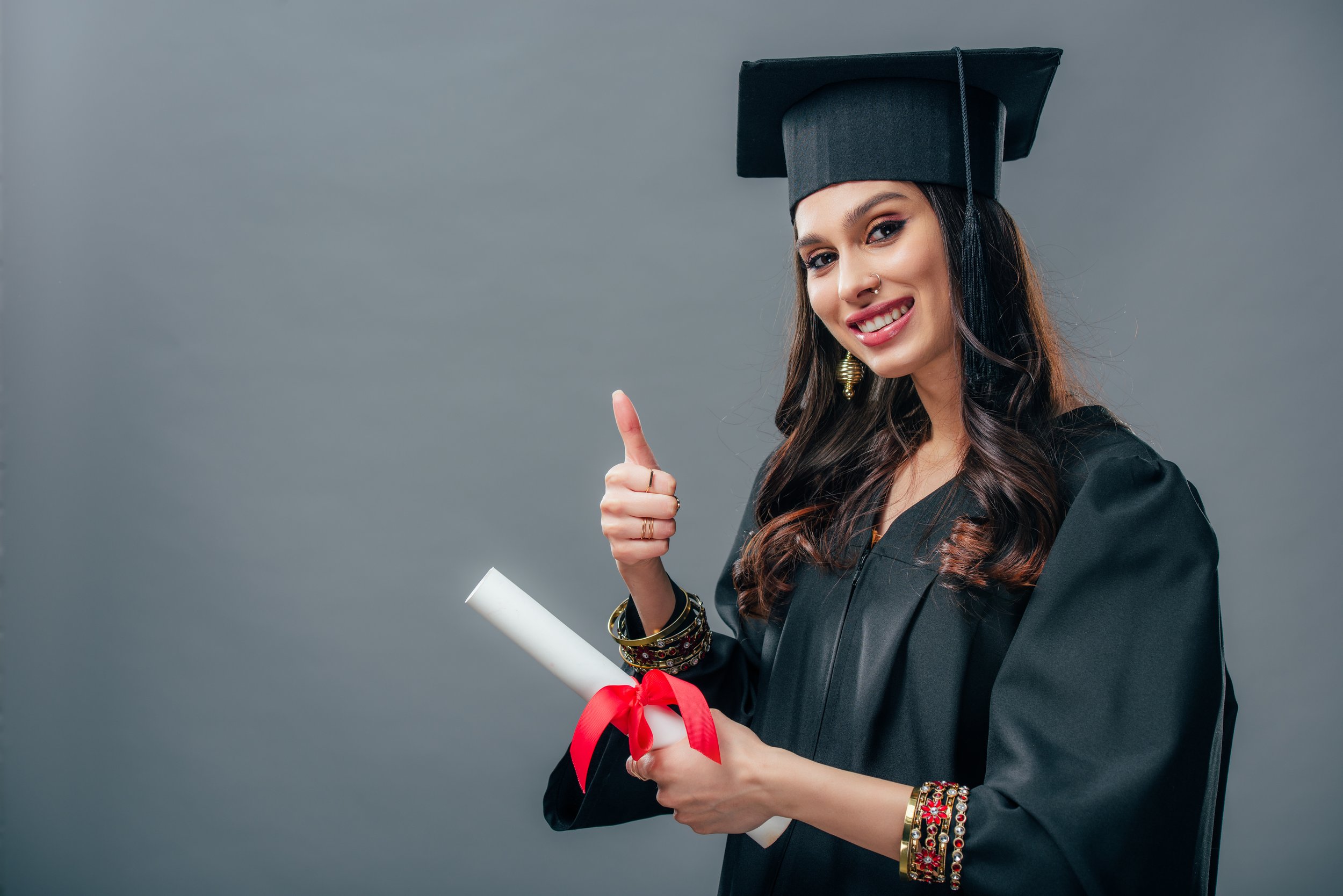 smiling-female-indian-student-in-academic-gown-and-2024-11-17-16-44-29-utc.jpg
