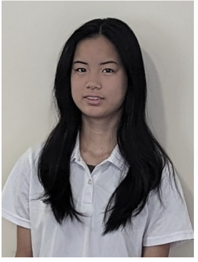 Young person with black hair wearing a white polo shirt with a logo that says 'Ustart Teaching' standing against a plain white wall.