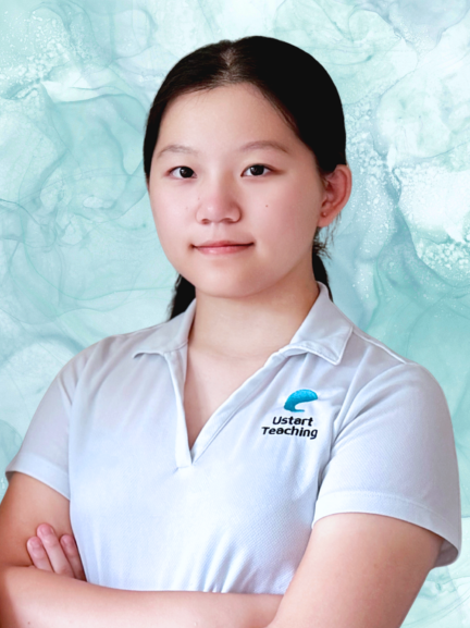 Young woman with dark hair in the back, smiling, wearing a white polo shirt with a logo and the words "Ustart Teaching," standing in front of a blue abstract background.