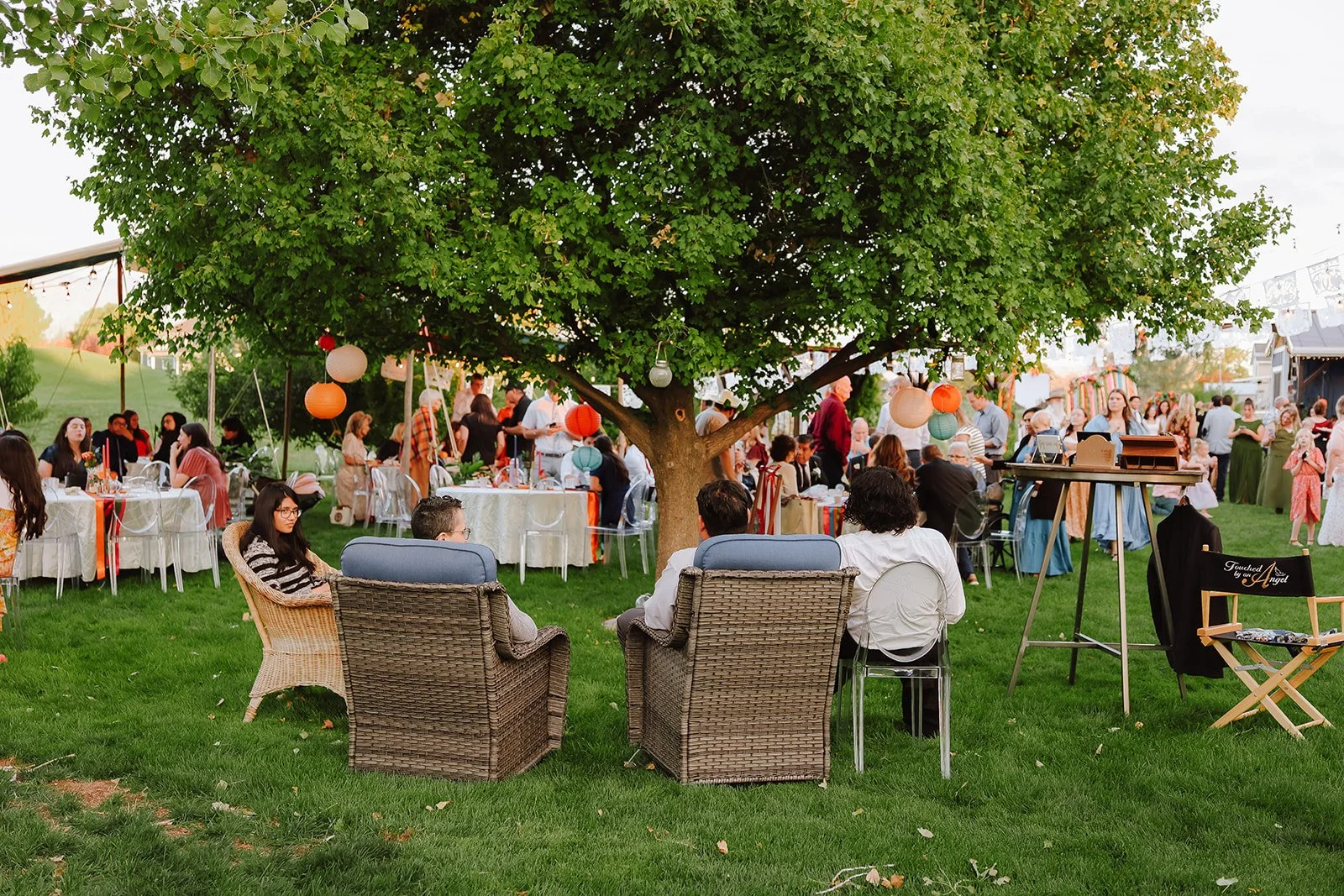 Photograph of a bride and groom in front of colorful decor for their backyard wedding reception syracuse, utah