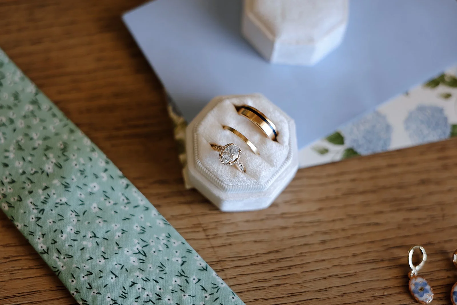 Photograph of a wedding flatlay with wedding ring and ties 