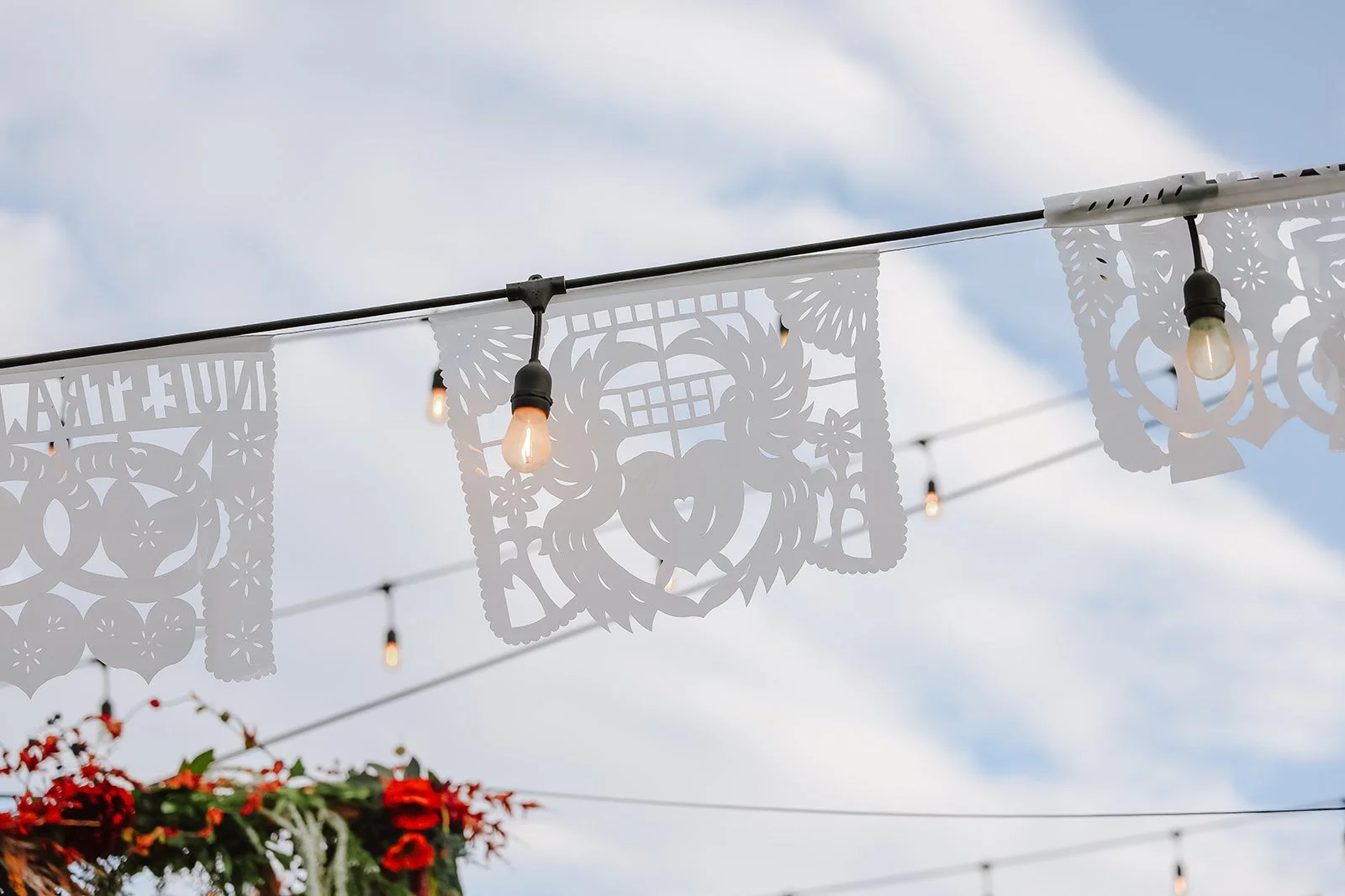 Photograph of a bride and groom in front of colorful decor for their backyard wedding reception syracuse, utah