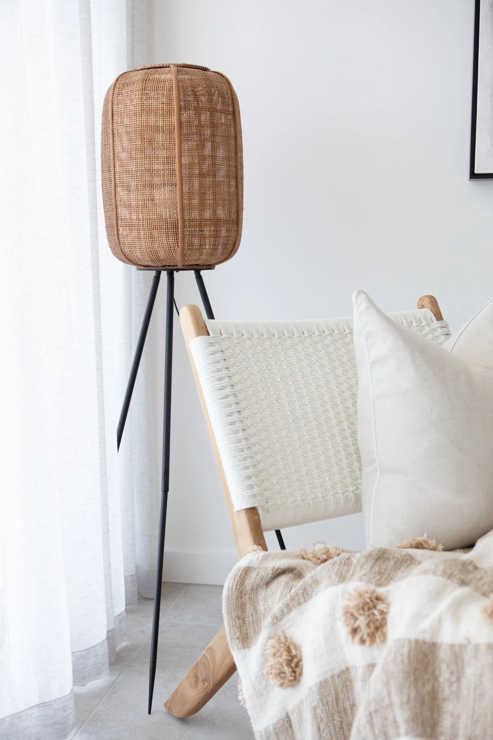 Rattan floor lamp and soft neutral textures in Queensland living space