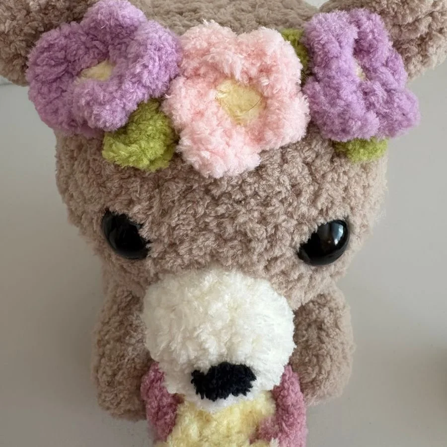 view from the top of a crochet honey bear showing the purple and pink flower crown on its head