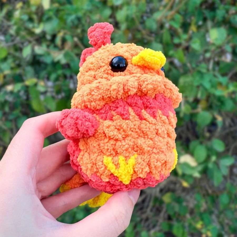 bottom angle view of little crochet phoenix showing embroidered feet