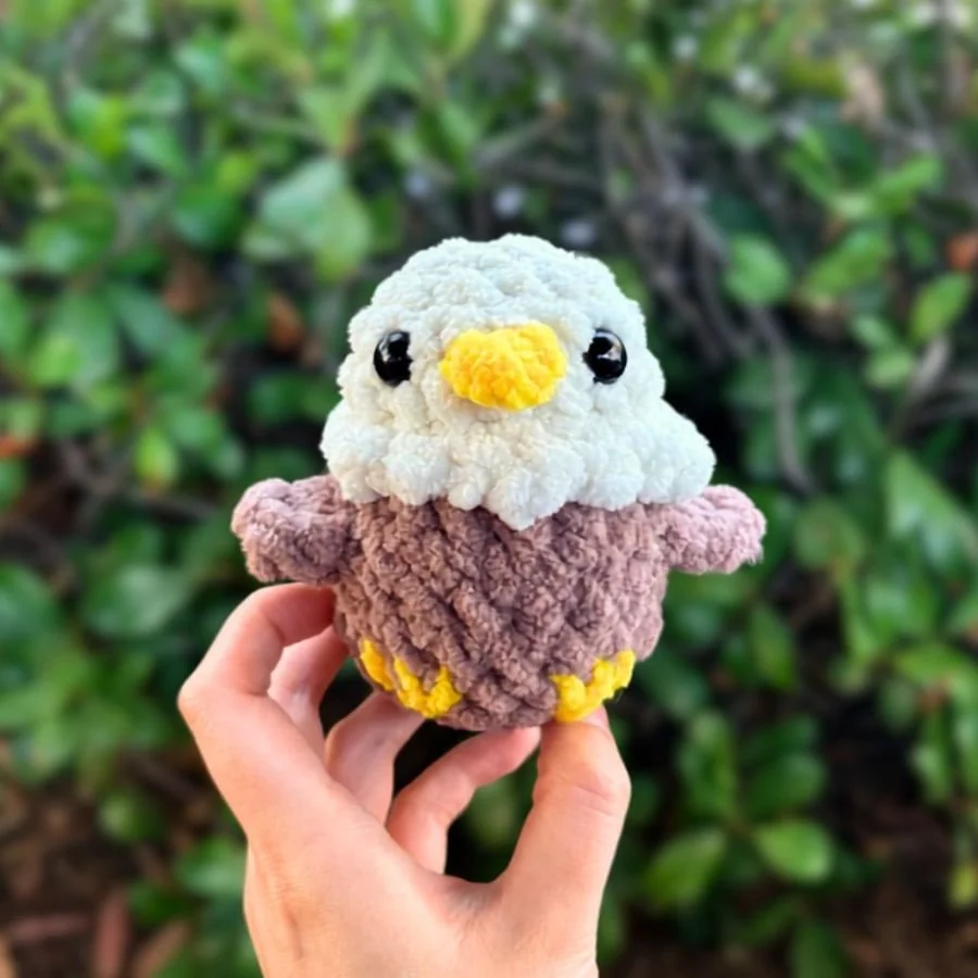 small crochet bald eagle bird that's held up by a hand - free crochet eagle pattern - no sew eagle little amigurumi free pattern