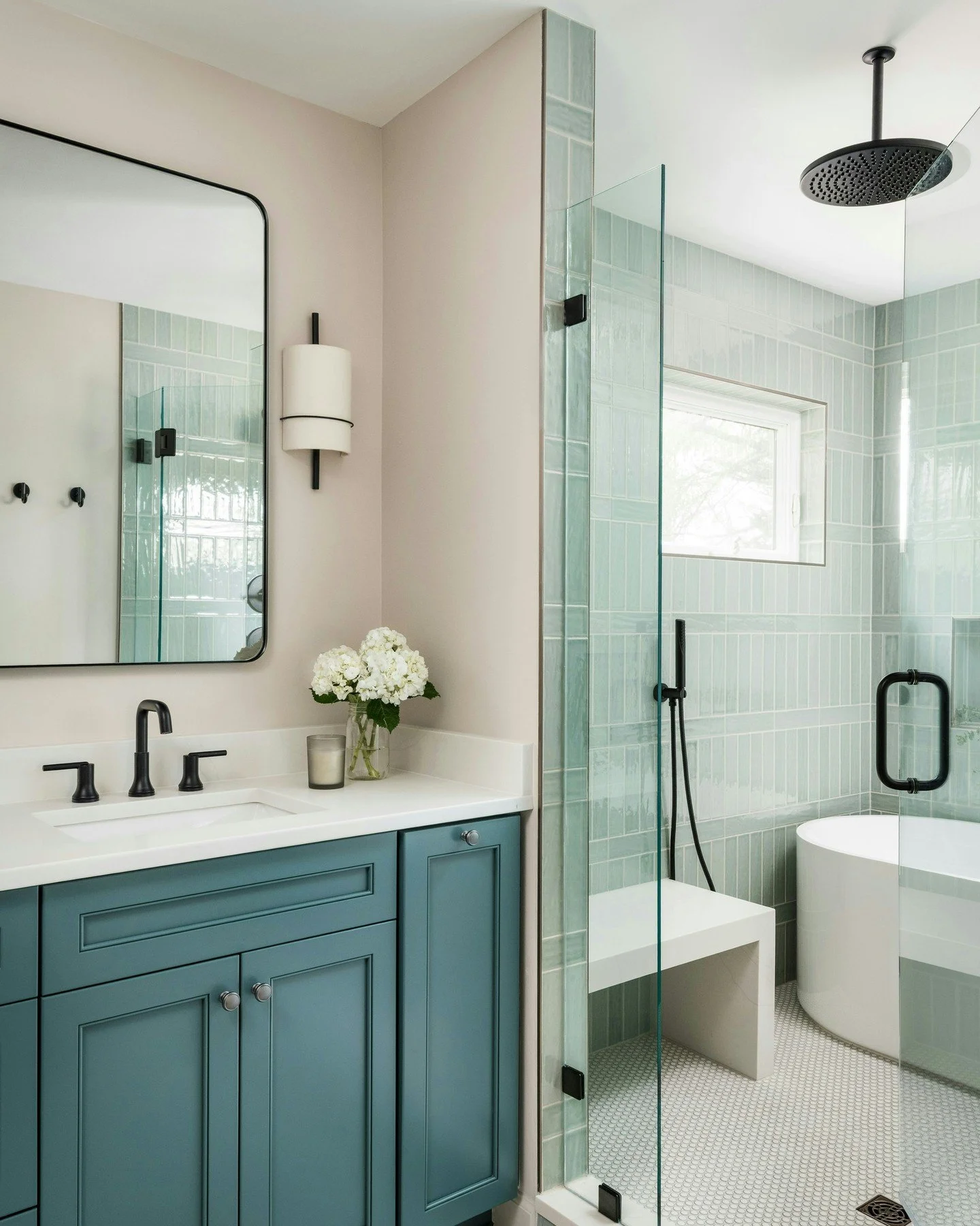 Beyond the tilework, this Montford primary bath came together through contrast and balance. Soft blue cabinetry, crisp white countertops, and matte black fixtures that ground the entire space.
Every finish was selected to feel calm, layered, and time