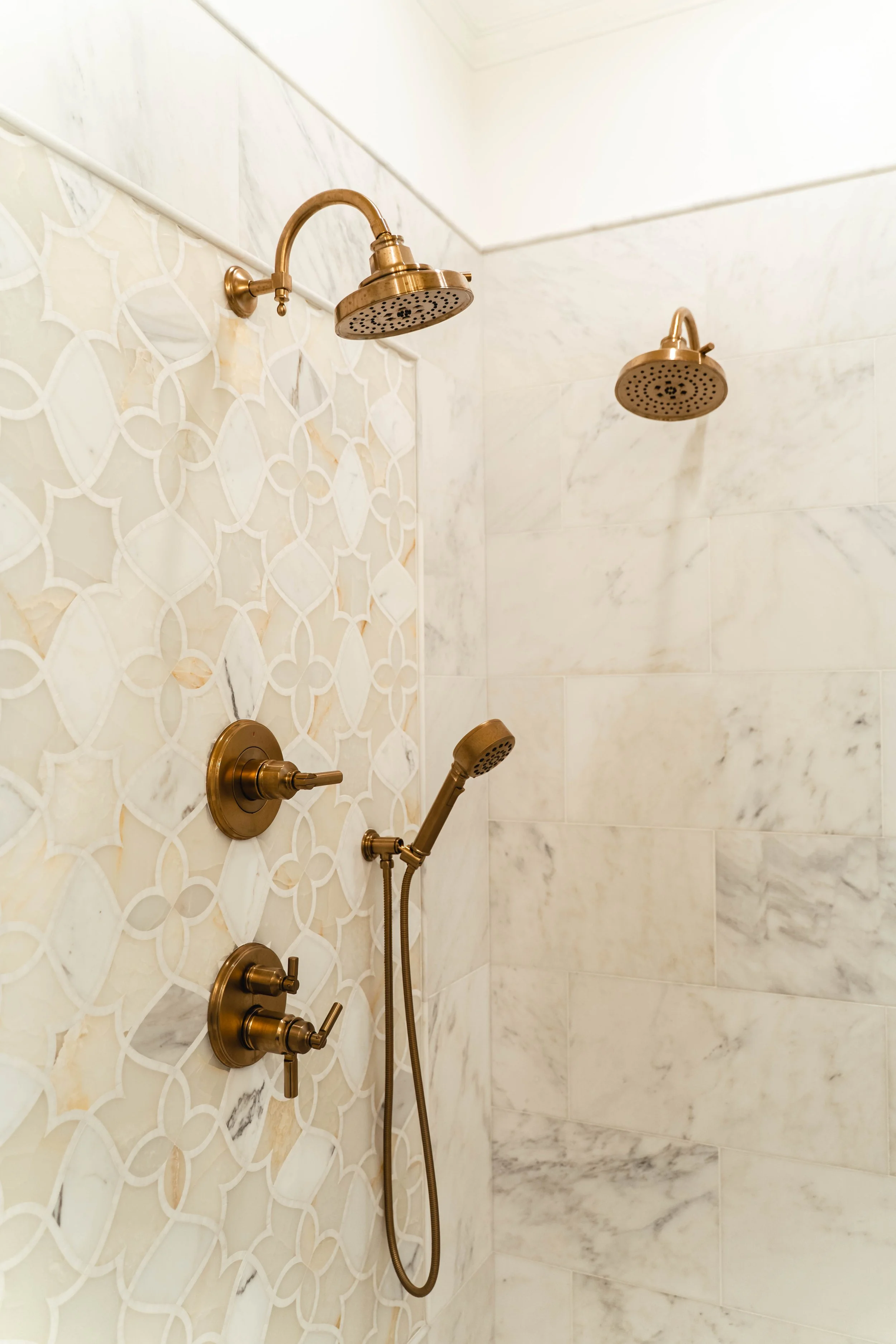 Matthews Bathroom Renovation with Custom Tile work, warm brass shower fixtures, and a thoughtfully designed double shower system for both beauty and everyday function.