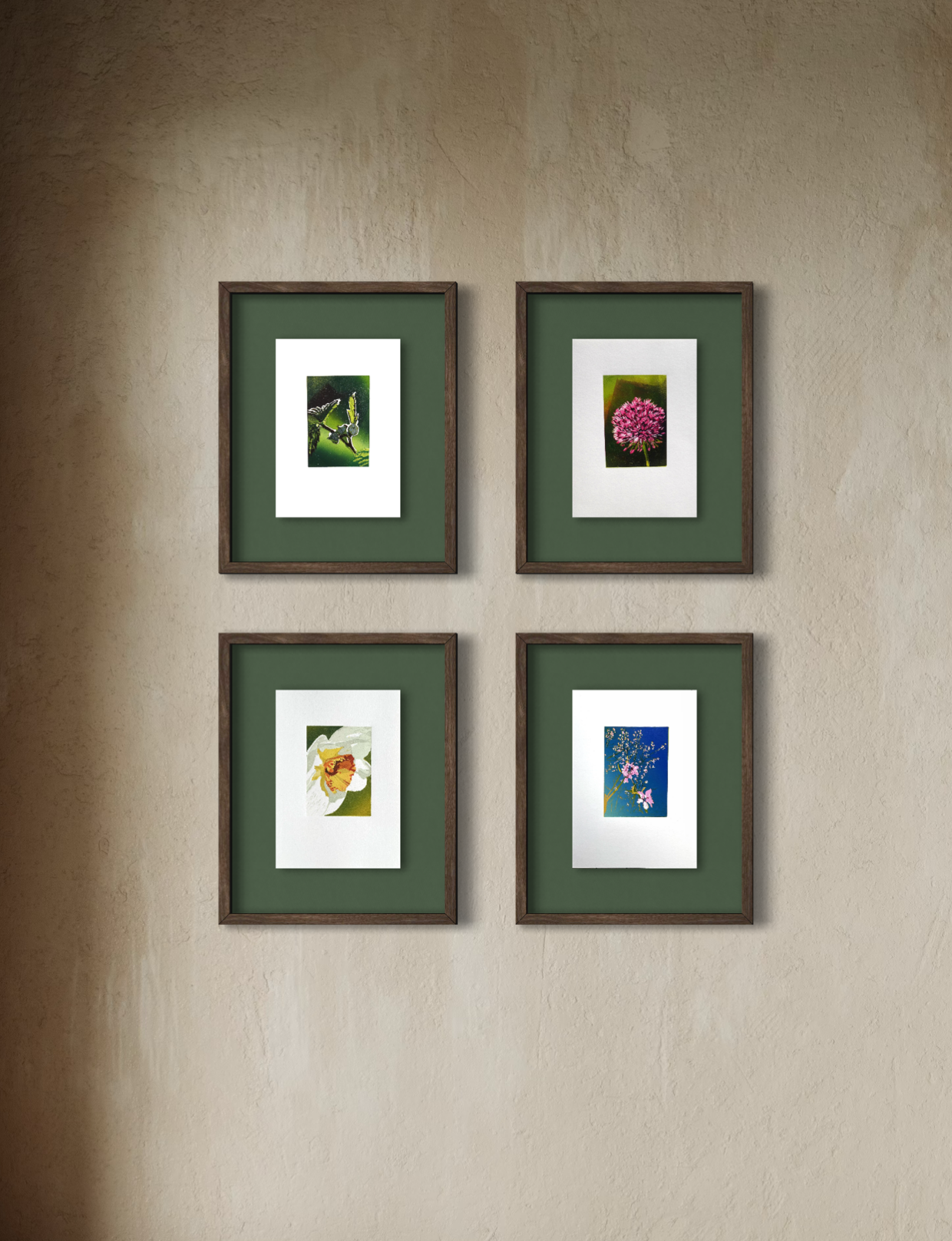 Four framed floral linocut prints hung on a beige wall in a 2x2 grid, each with a green mat and wooden frame.