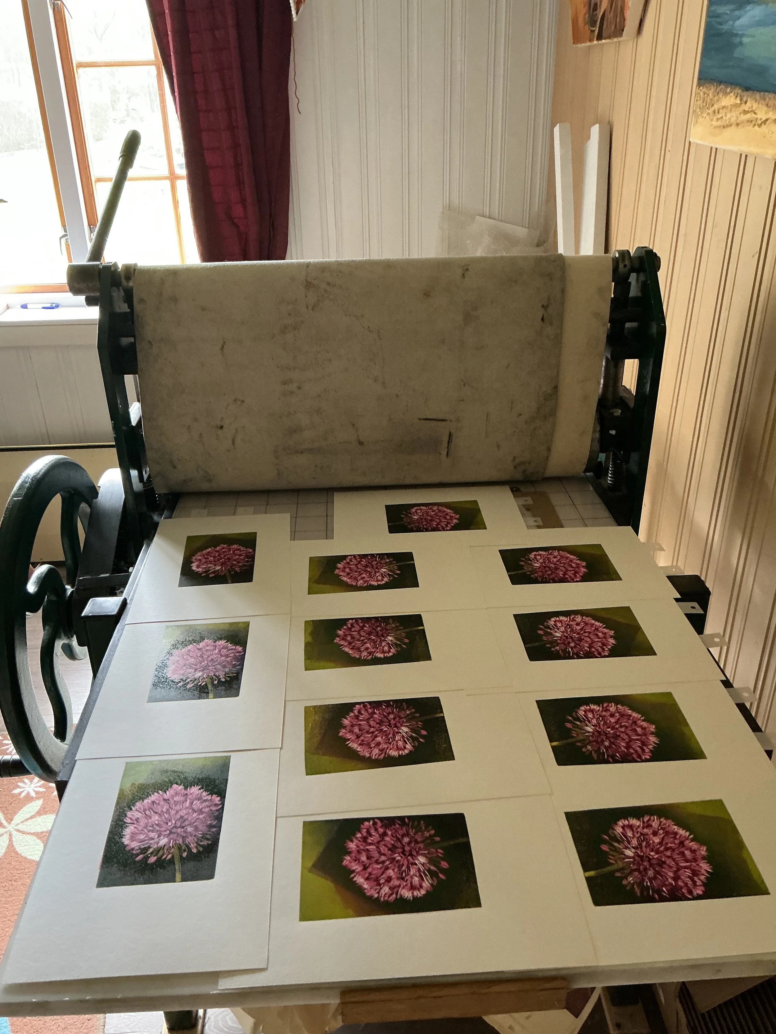 A table covered with sheets of paper featuring prints of pink flowers, arranged in a grid pattern.