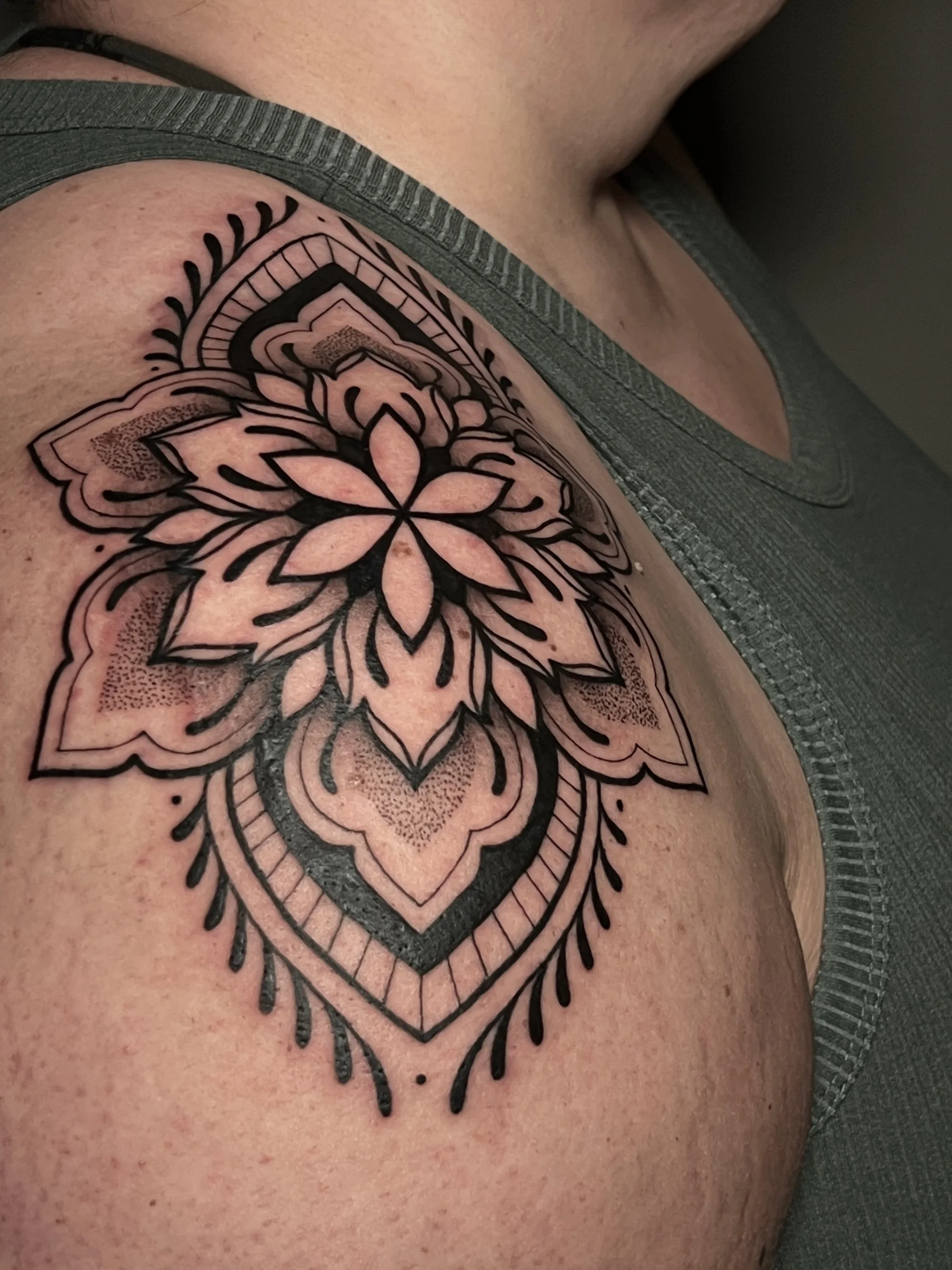 Bold ornamental shoulder tattoo with thick lines and fine details, designed and tattooed by Maya Wild at Sub Rosa Tattoo Studio in Grants Pass, Oregon. This piece highlights symmetry and precision. Ideal for clients looking for bold yet feminine tatt
