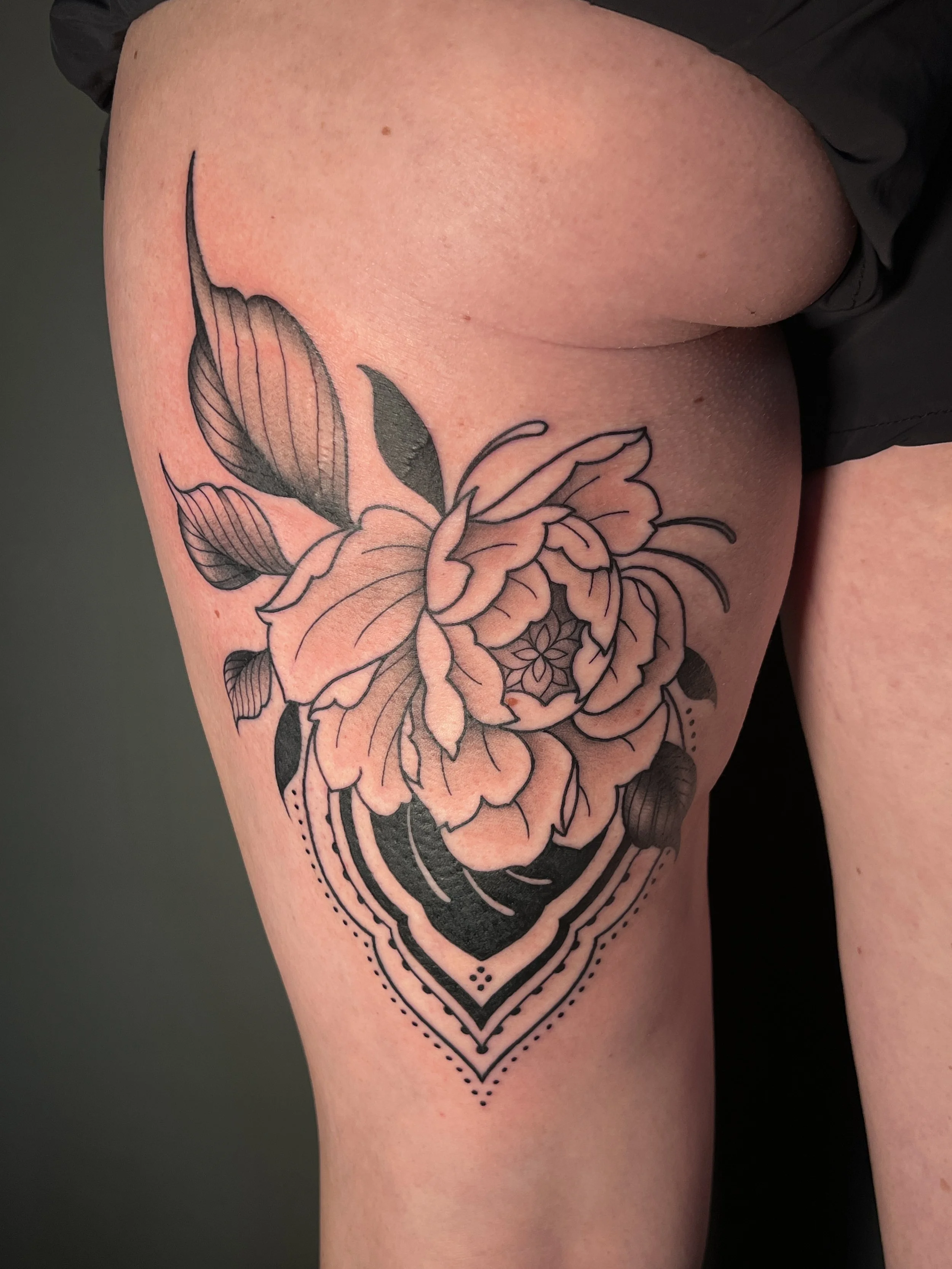 Floral ornamental thigh tattoo with soft details, designed and tattooed by Maya Wild at Sub Rosa Tattoo Studio in Grants Pass, Oregon. This intricate piece highlights flow and symmetrical elements to flatter the thigh and butt. Ideal for clients look