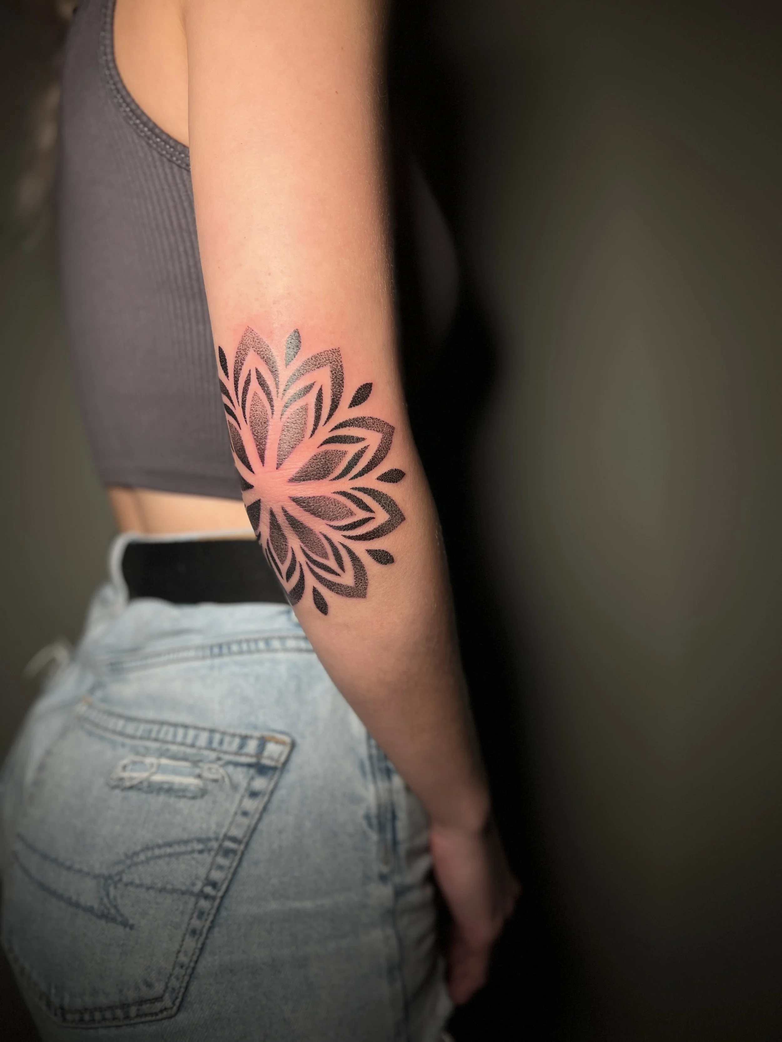 Ornamental mandala elbow tattoo with dotwork details, designed and tattooed by Maya Wild at Sub Rosa Tattoo Studio in Grants Pass, Oregon. This intricate piece highlights symmetry and floral elements to flatter the arm. Ideal for clients looking for 