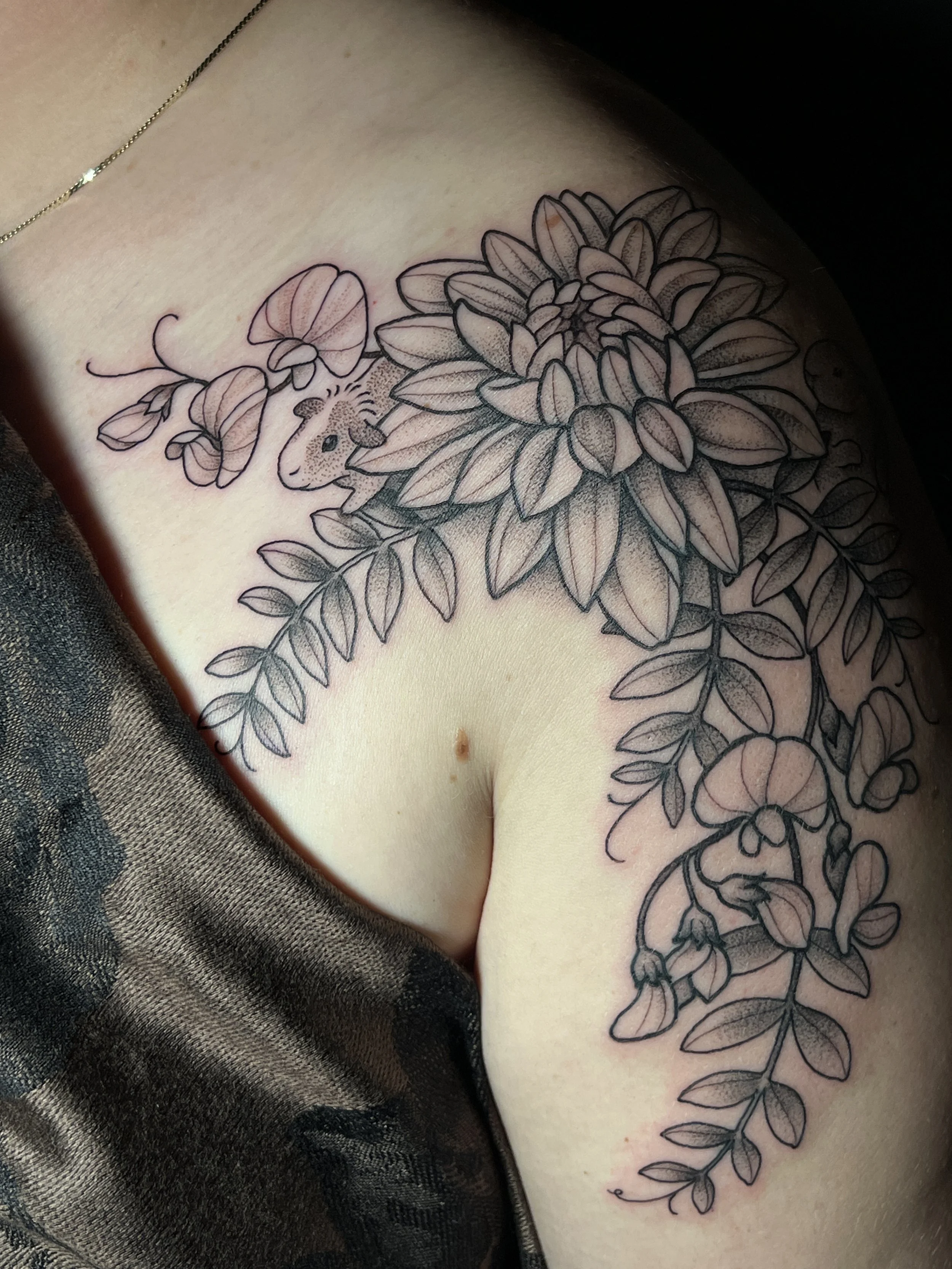 Floral and botanical pet memorial tattoo with high contrast details, designed and tattooed by Maya Wild at Sub Rosa Tattoo Studio in Grants Pass, Oregon. This intricate piece highlights fit and flow to flatter the chest and shoulder. Ideal for client