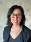 A woman with shoulder-length dark hair, glasses, and red lips
