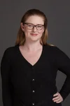 a person with long light hair and glasses