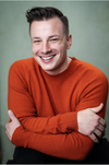 RP smiles in a red sweater