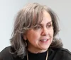 A woman with gray hair looks away from the camera