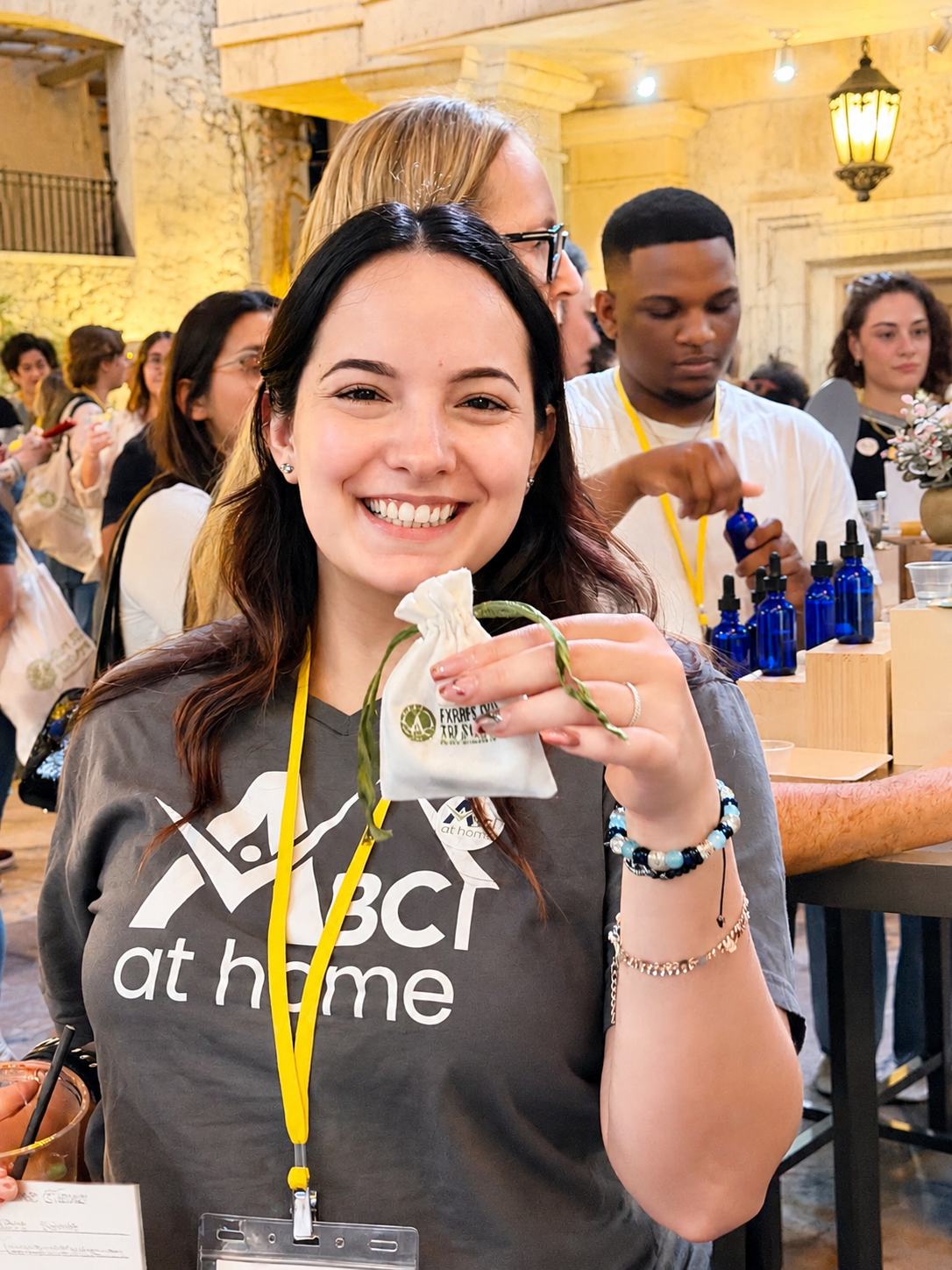 a women holding a fabric bag and a man opening a blue perfume oil bottle in background