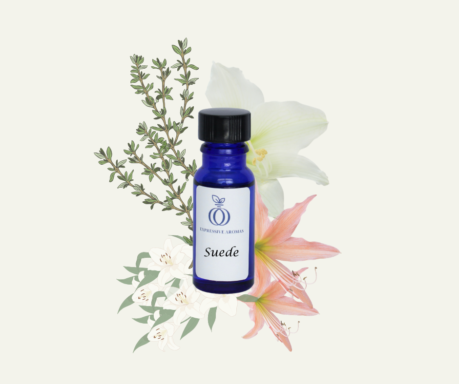 Blue “Suede” fragrance bottle from Expressive Aromas surrounded by subtle earthy elements.