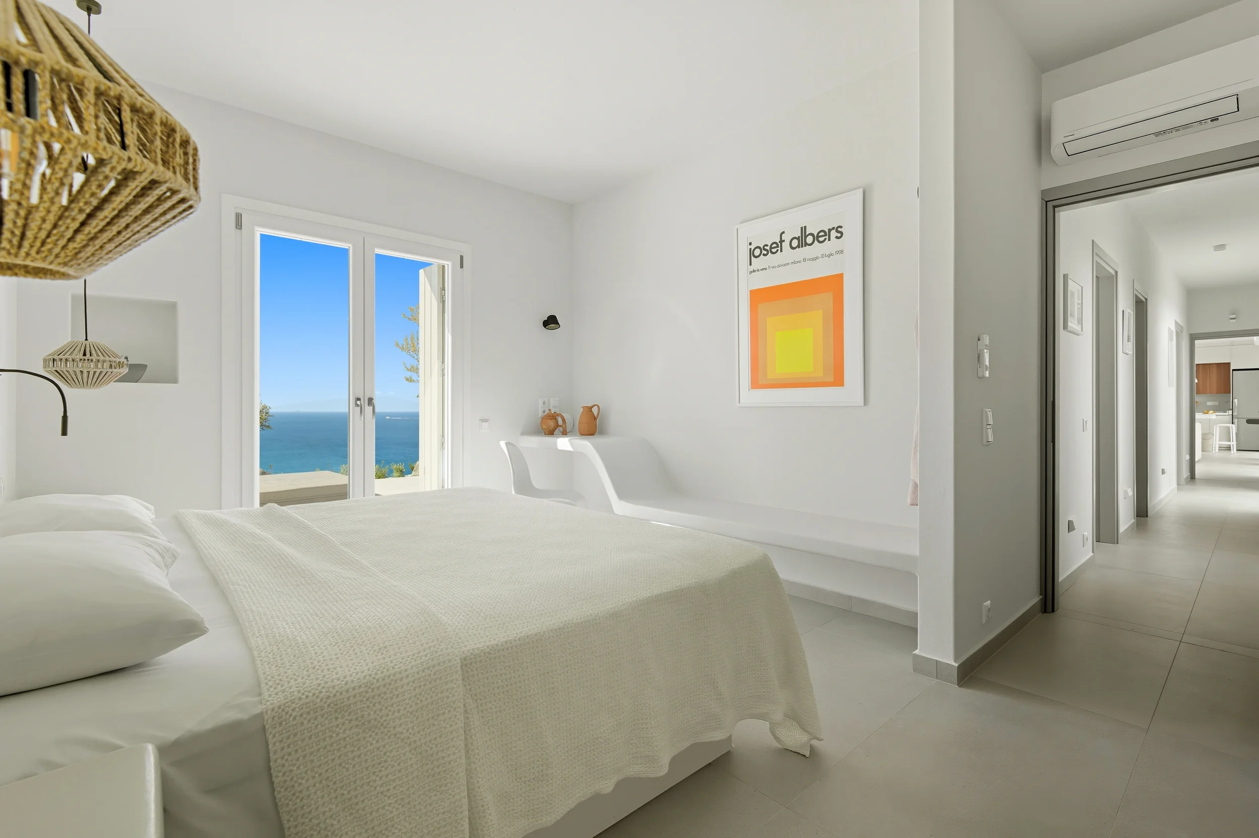 Luxury villa bedroom suite with sea view and boho rattan decor — real estate photographer Naxos Greece