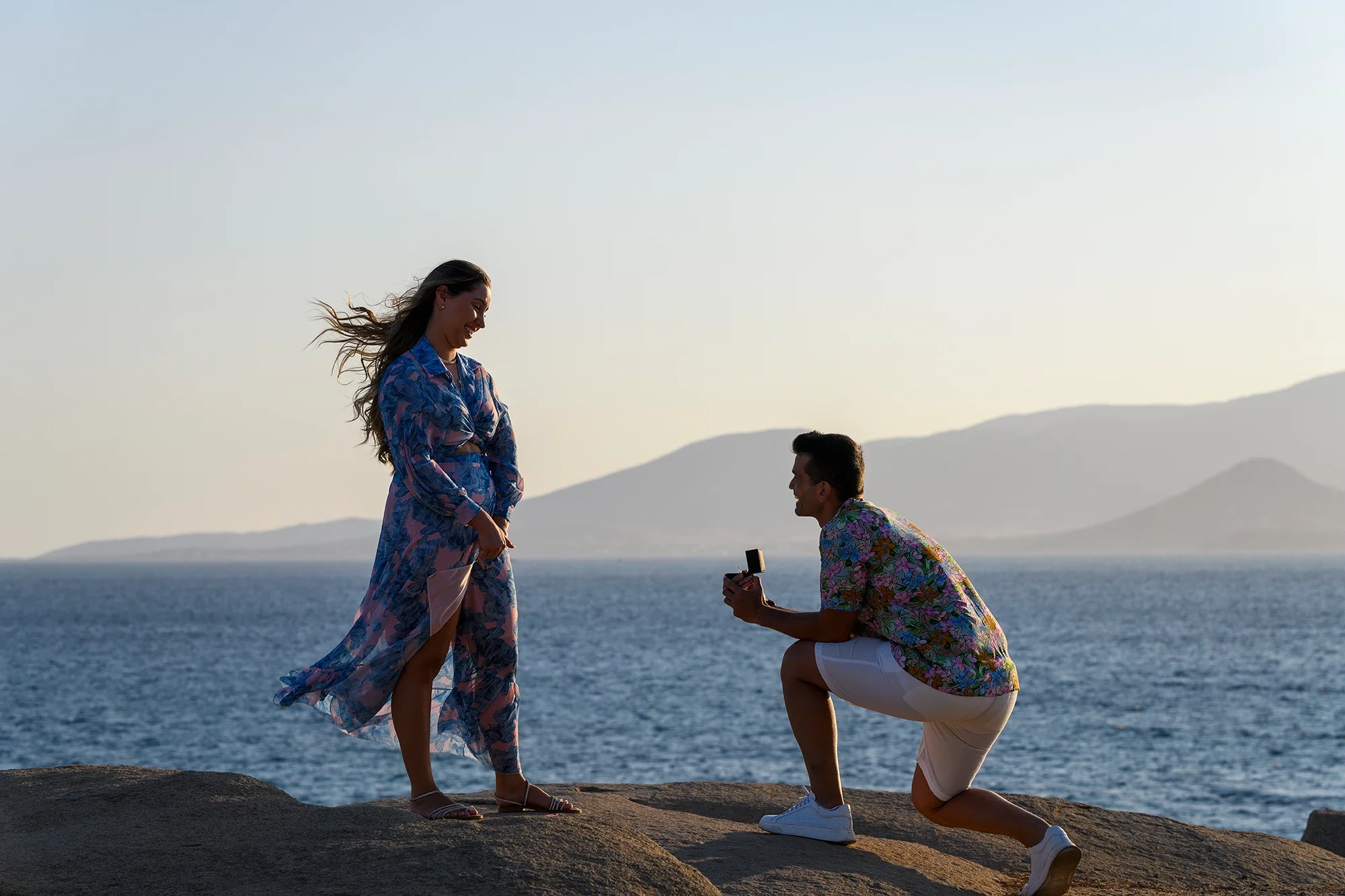 Surprise proposal on the Naxos coastline with mountains and sea in the background
