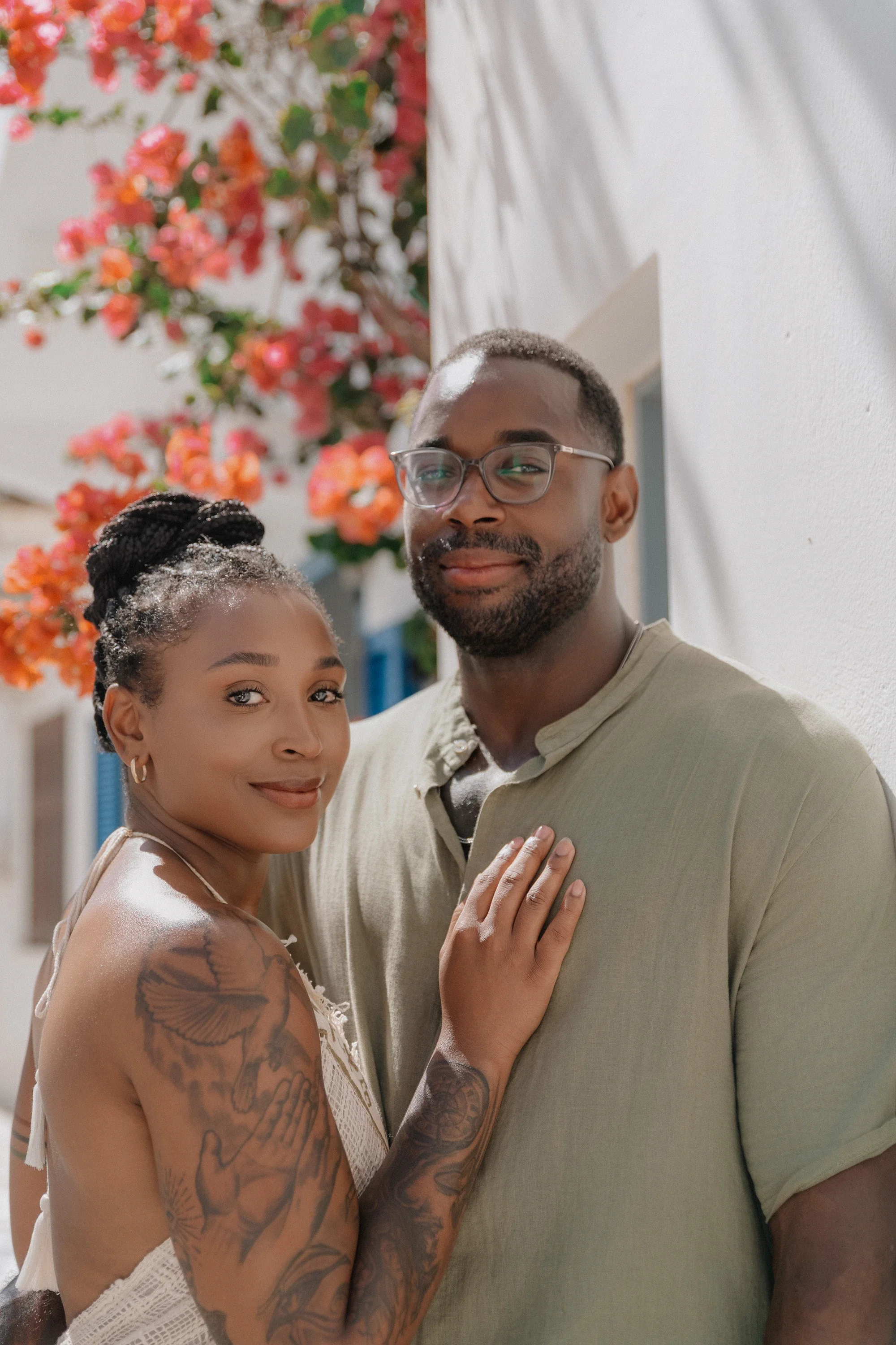 Couple's photography in Naxos Old Town, a couple in a quiet embrace beneath blooming bougainvillaea against a whitewashed wall.
