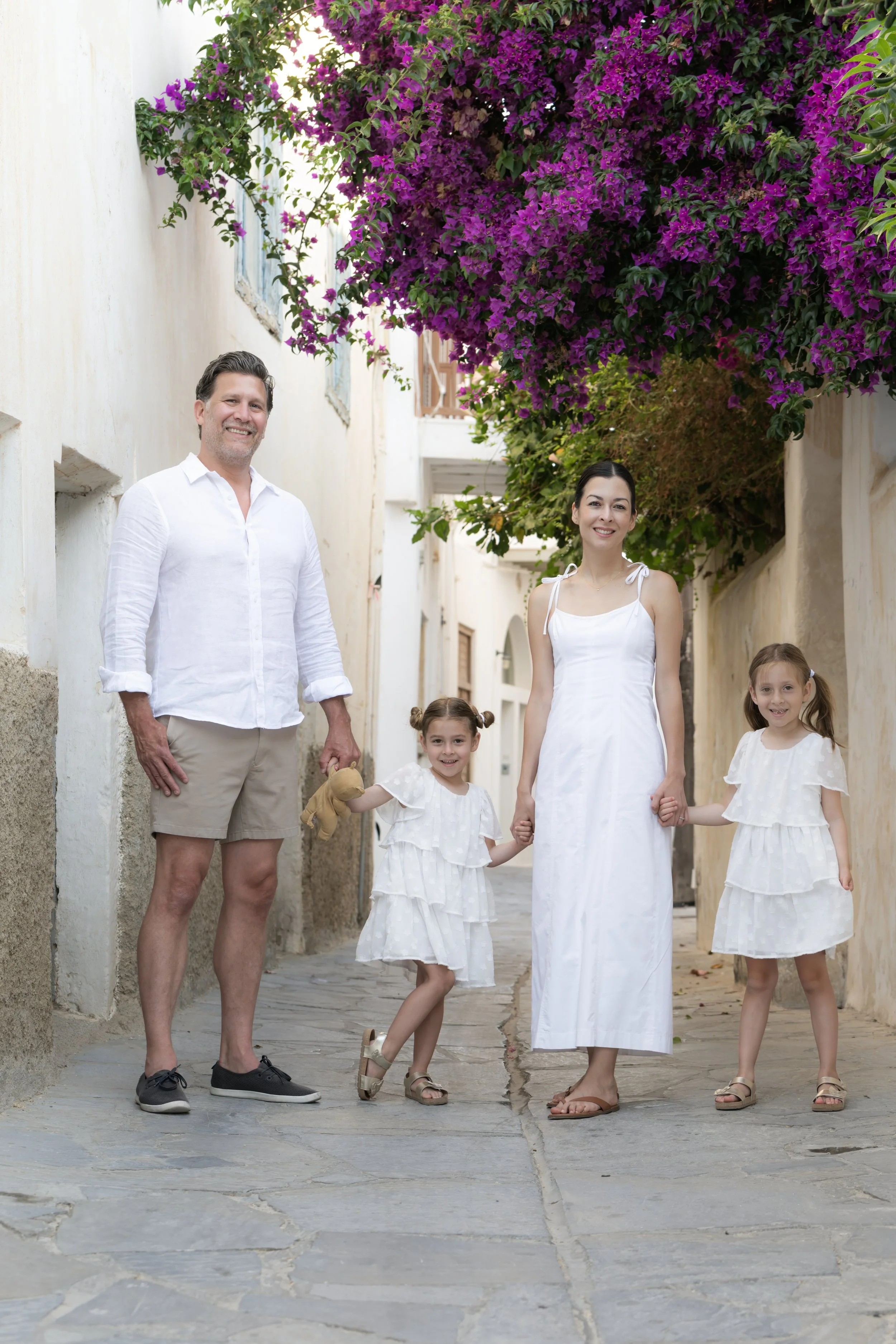 Family portrait beneath colourful bougainvillea in Naxos Old Town photographed by Naxos Photographer.