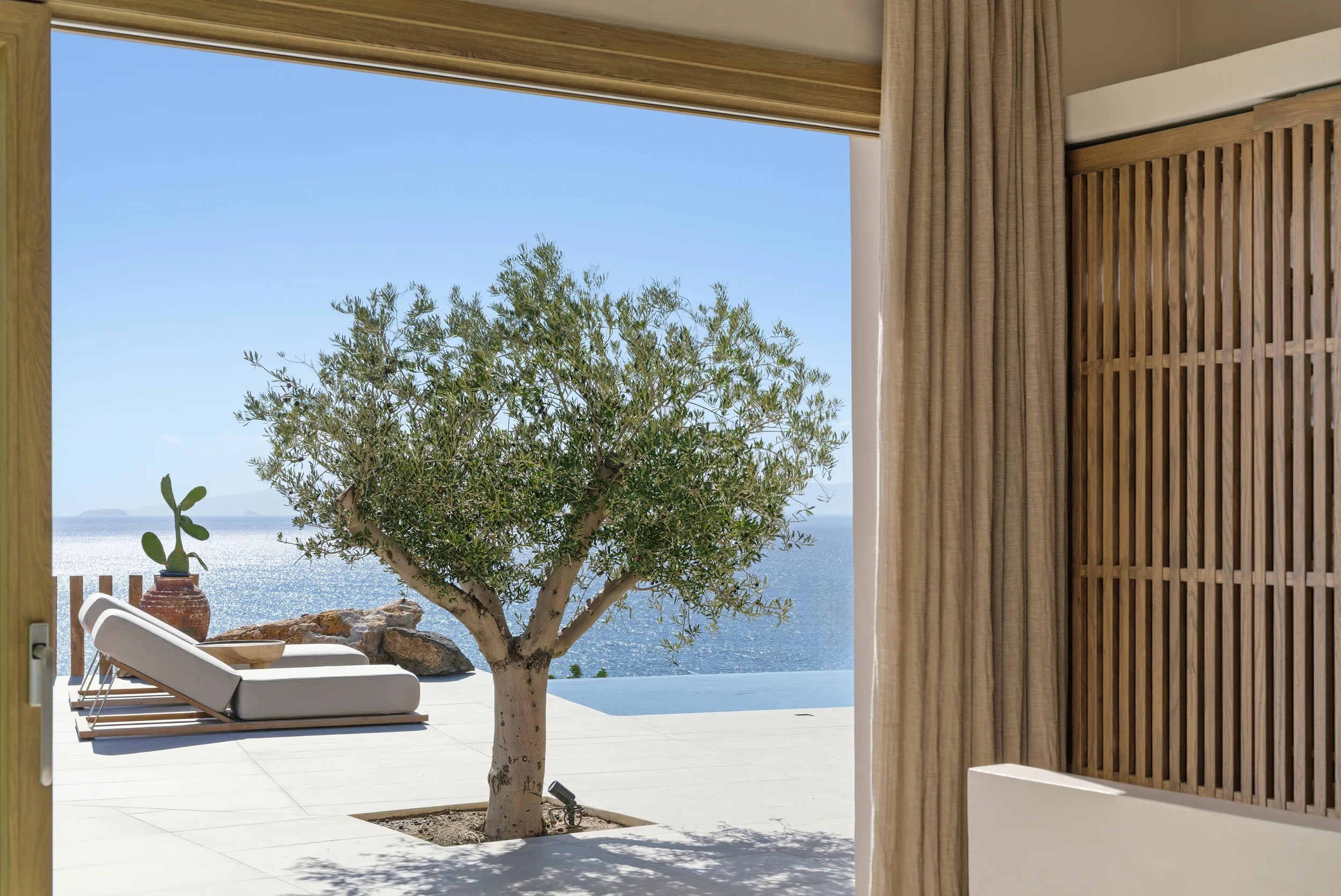 Luxury villa terrace with olive tree, infinity pool and Aegean sea view — real estate photographer Naxos Greece