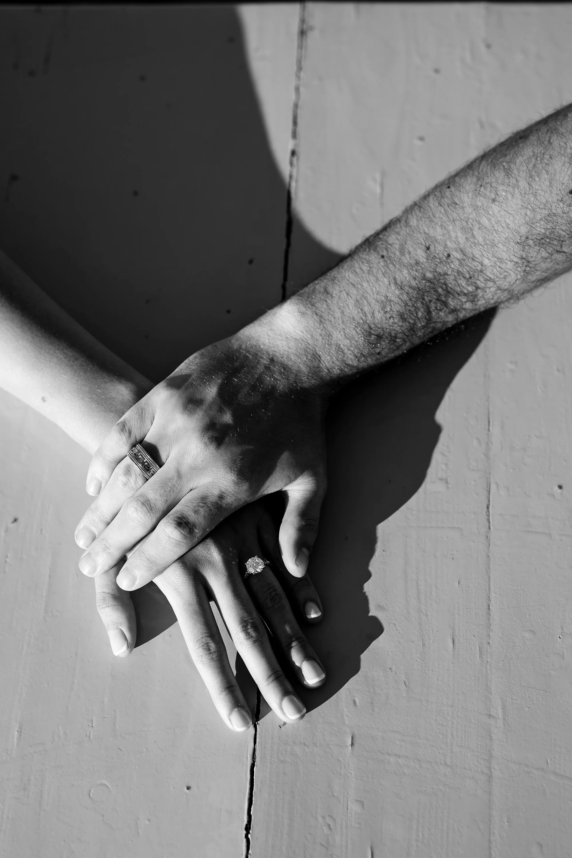 Black and white detail of couple holding hands with engagement ring in Naxos