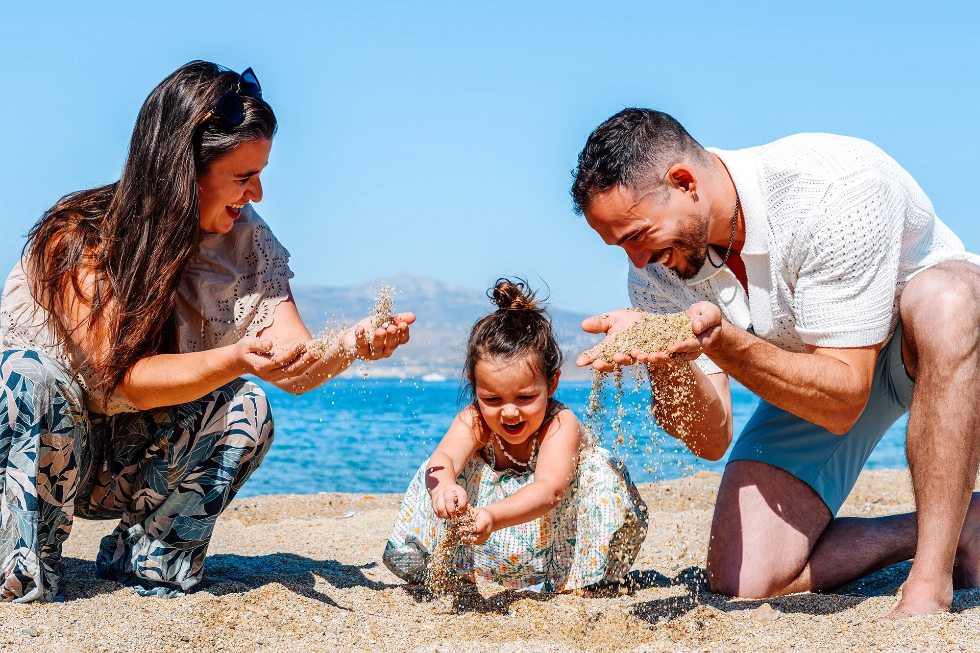 Family playing with sand on a Naxos beach during a vacation photoshoot