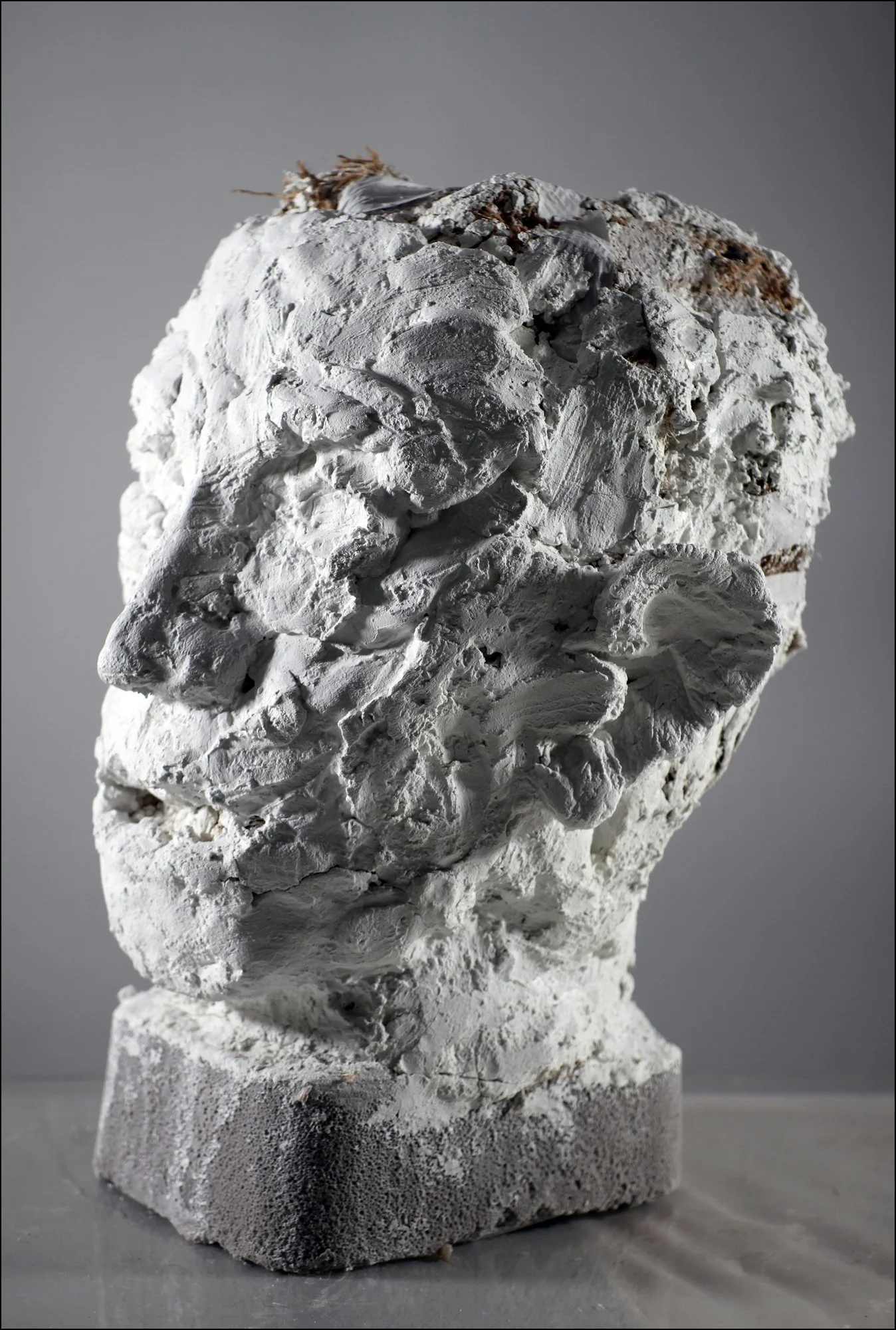 Large Head (2026), Winterstone, burlap, masking tape, cement base, 16 ¼ x 12 x 12 ¾ inches (side view)